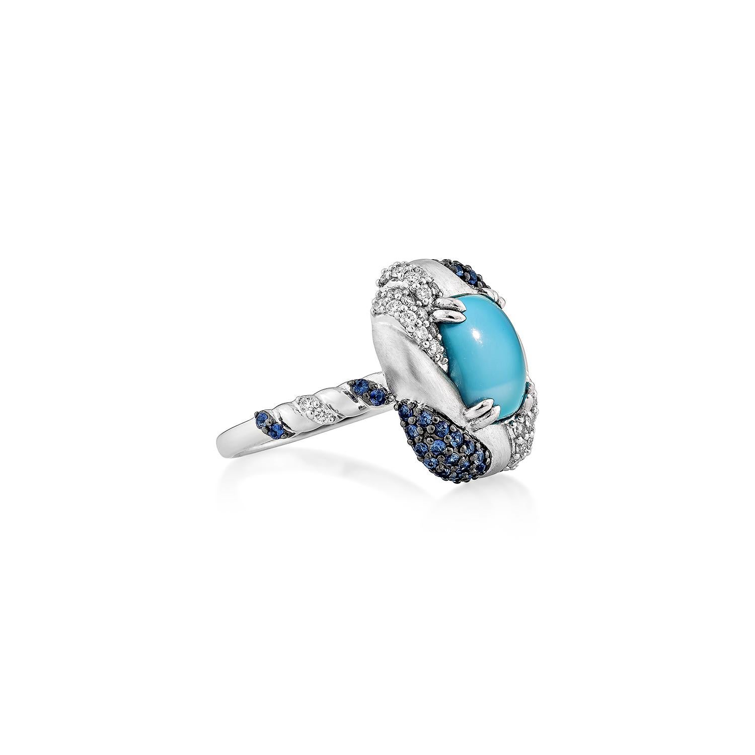 Elegante anello Fancy in turchese realizzato in oro bianco 14K, con centri di turchese cabochon liscio avvolti da un suggestivo turbinio di zaffiri blu e diamanti scintillanti. Un design artistico e vivace che unisce colori vivaci e artigianato di
