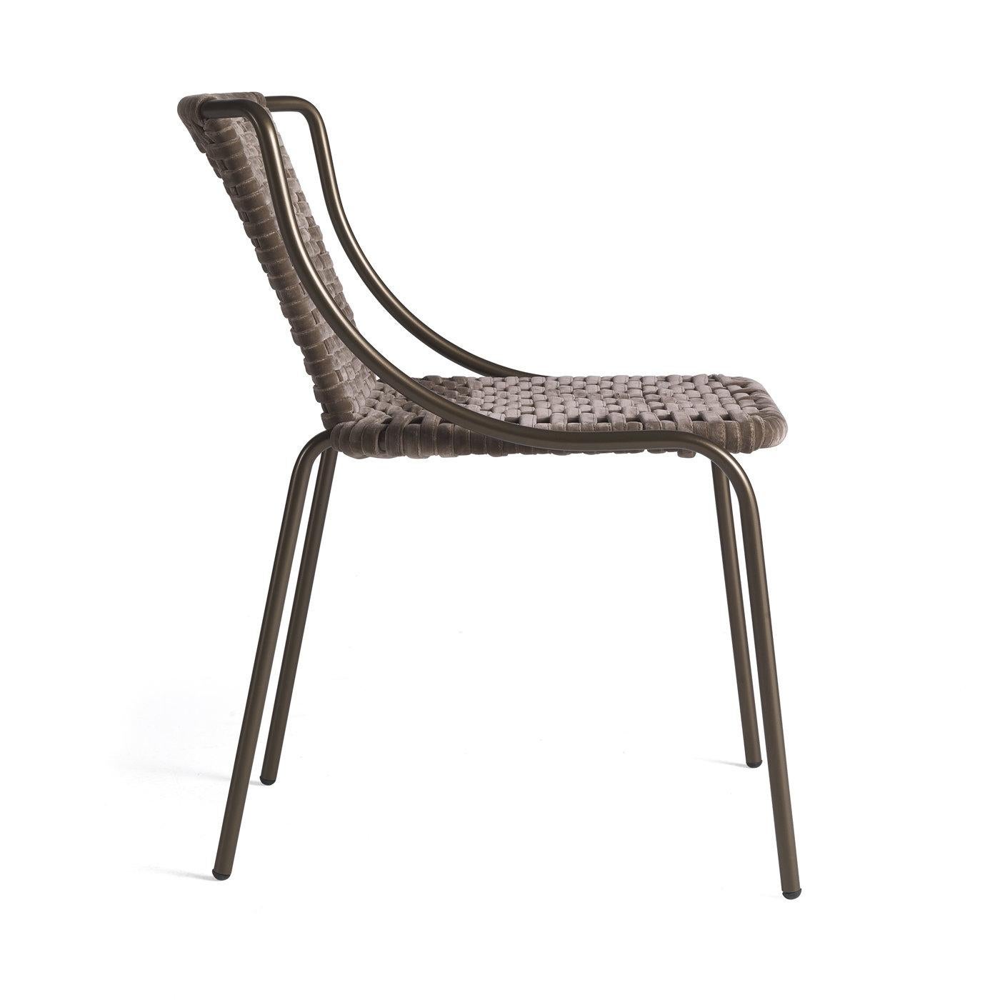 This chair is a splendid versatile piece that will complement any dining table from the same collection. Composed of a sinuous, metal structure with slightly slanted legs, it is marked by a braided seat and back made of gunmetal gray velvet, adding