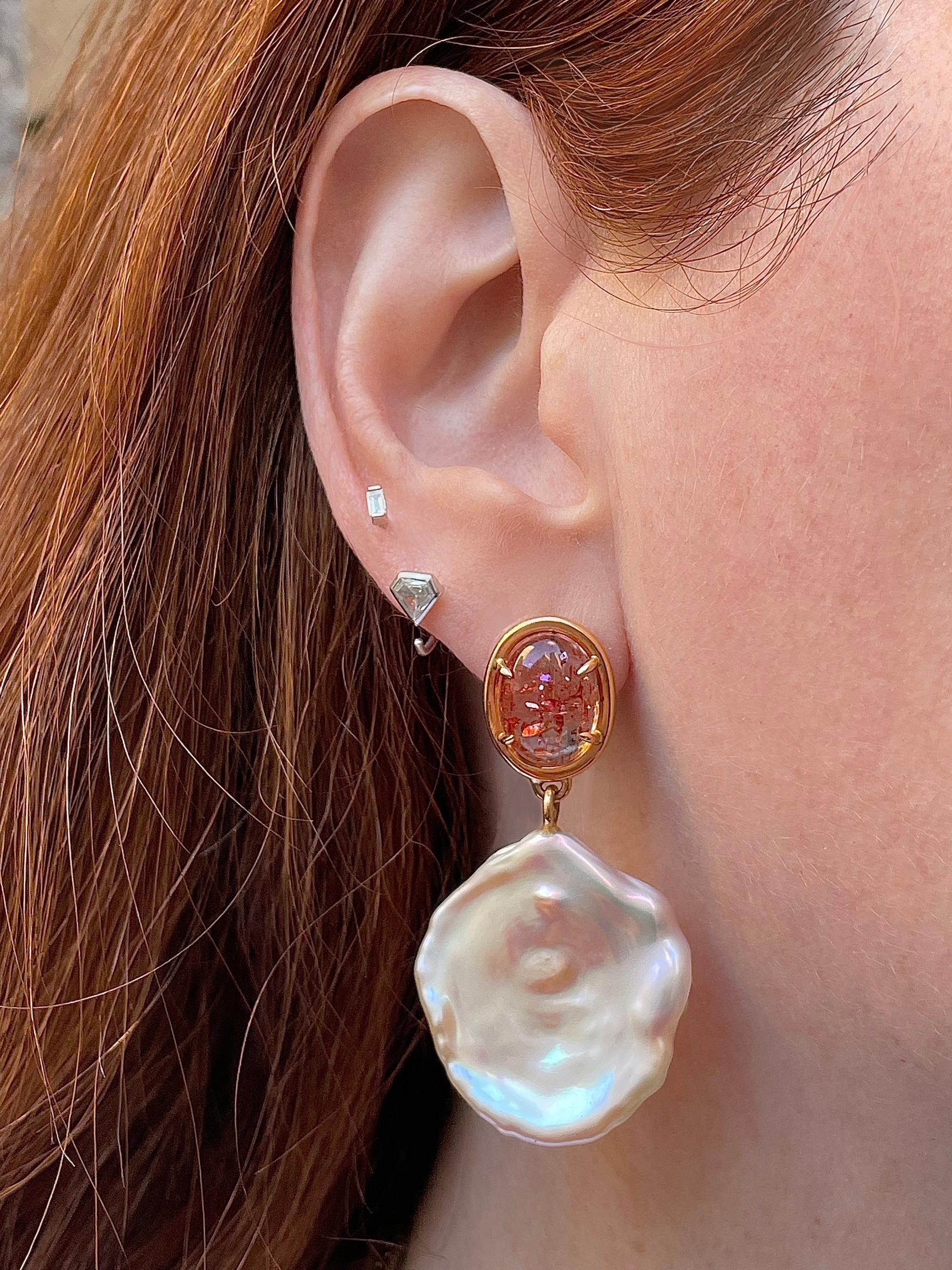 Gem quality oval sunstone cabochons (10X13mm) transparent and freckled auburn, are hand set in 18K rose gold. Dropping from these gems is the perfect color compliment-  a creamy and lustrous coordinated pearl pair in the most flattering peachy pink