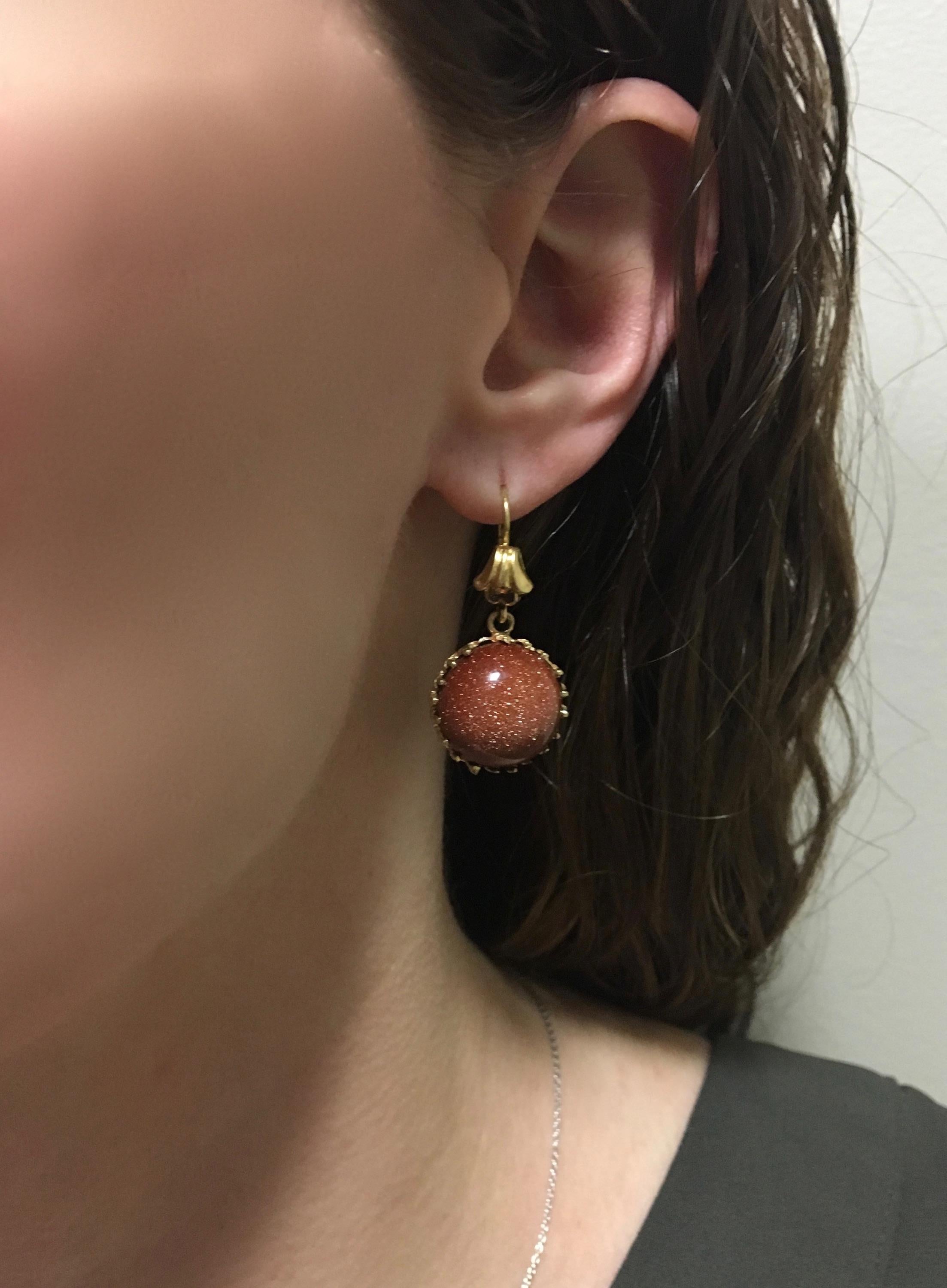 These beautiful lever back style earrings feature two Round Cabochon Cut Sunstones set in 18k yellow gold.

Gemstone: Sunstone
Gemstone Carat Weight: Approximately 17mm Round
Gemstone Cut: 2 Round Cabochon Cut
Metal: 18K Yellow Gold 
Marked/Tested: