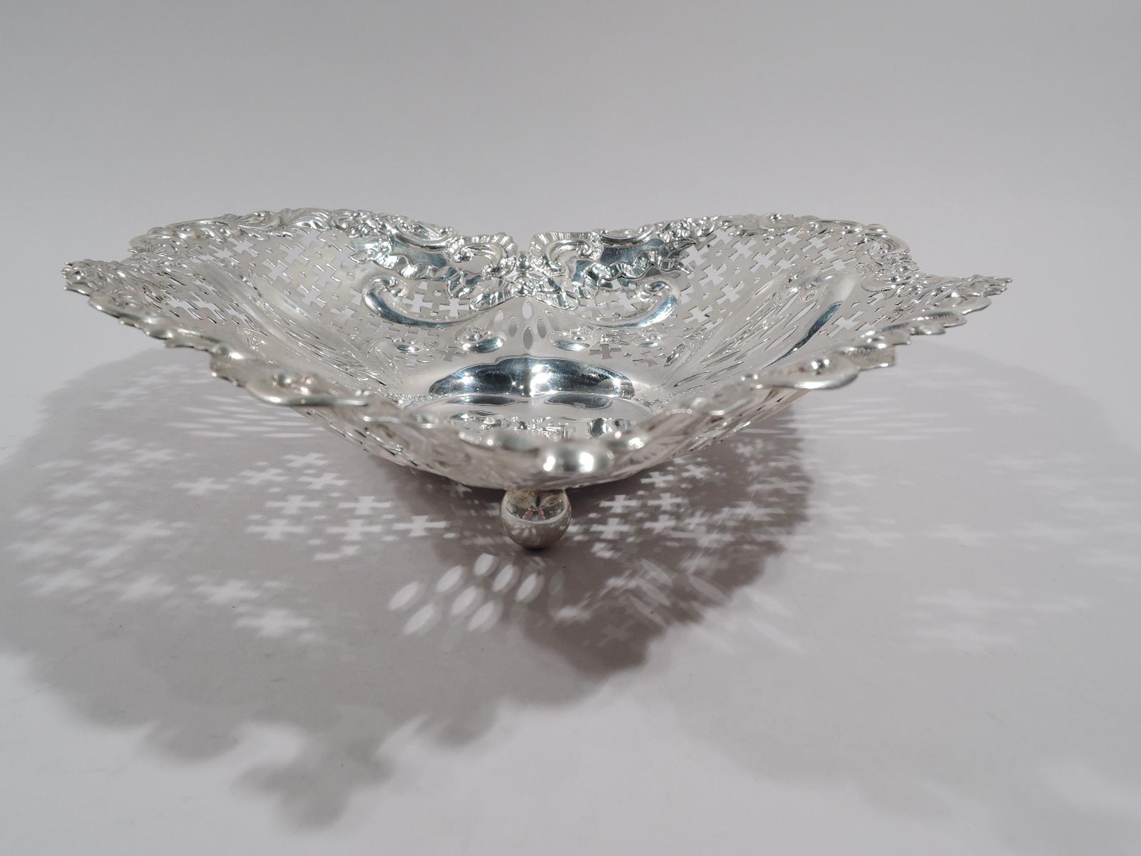 Super big and super romantic turn-of-the-century sterling silver heart bowl. Made by Gorham in Providence. Solid well; curved and tapering sides with chased scrolls and ribbon bows, and pierced geometric ornament. Irregular rim with scrolls, leaves,