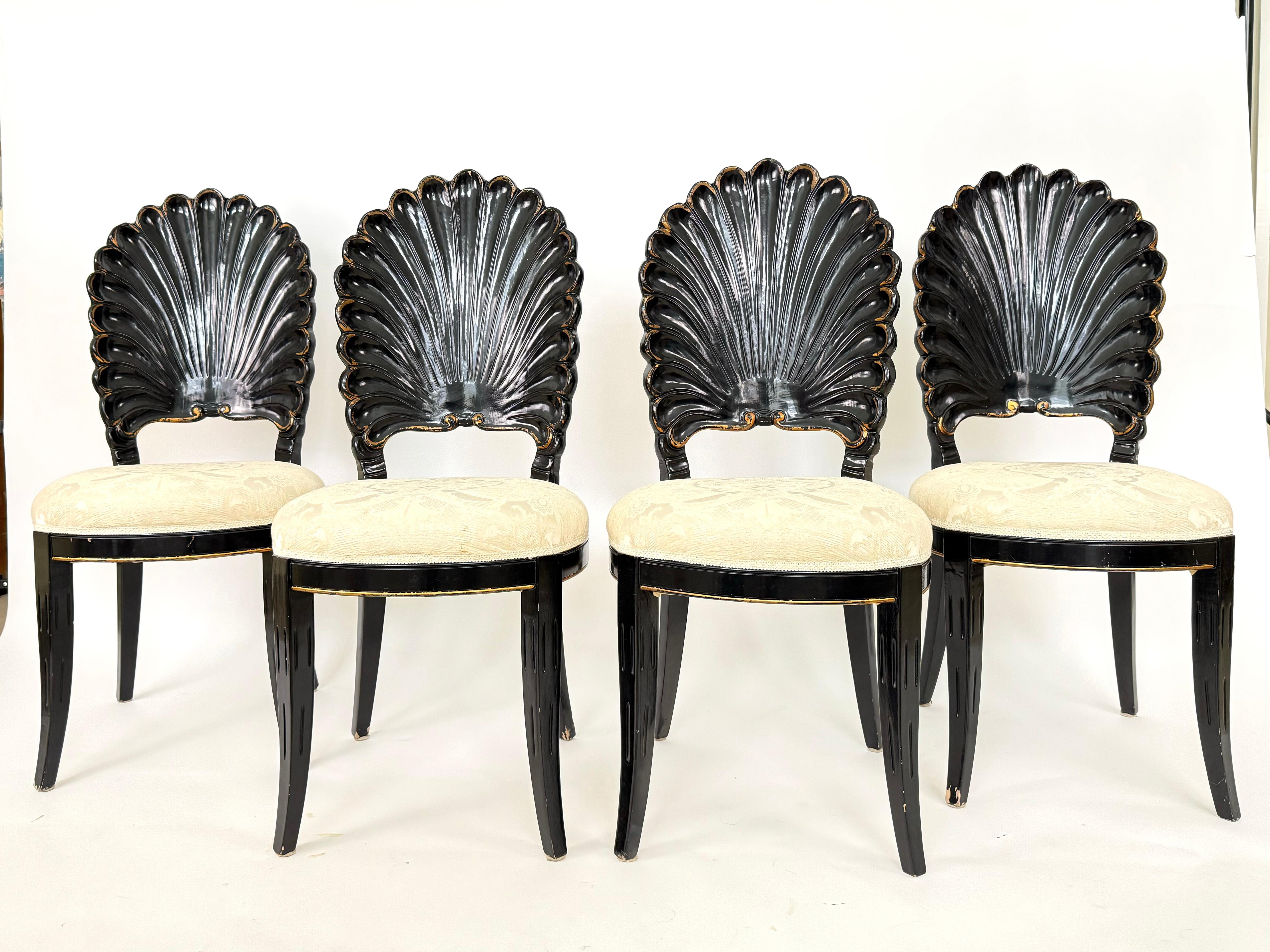 Lovely and timeless, this set of 4 clamshell chairs could be used with a dining table, game table, or simply as accent or desk chairs.  This set features the original black lacquer and gold accents, so will require restoration and reupholstery. 