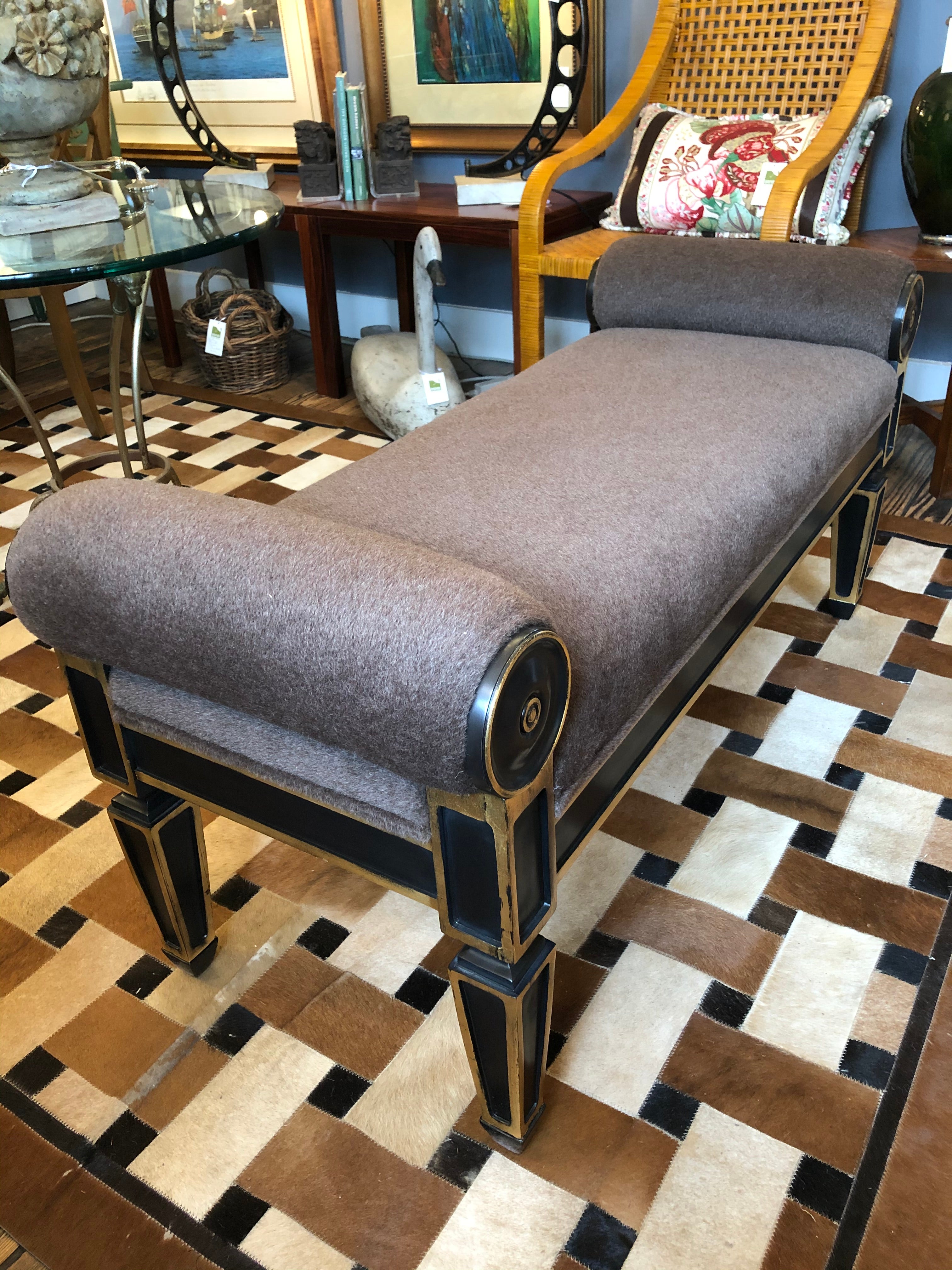 Super rich looking Hollywood Regency inspired designer bench having ebonized and gilded base with taupe plush mohair upholstery.