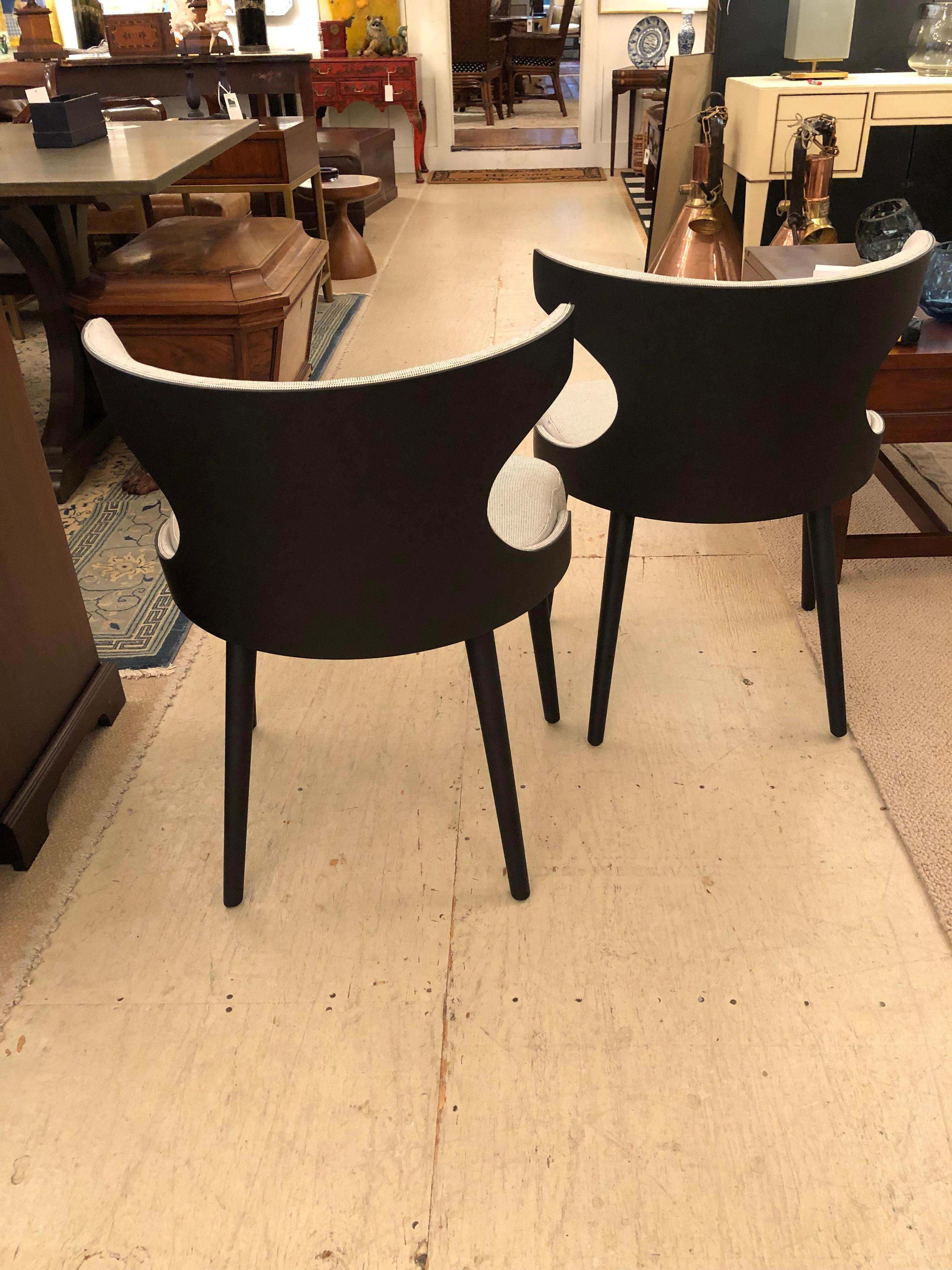 Super chic sculptural pair of modern Italian chairs with wonderful shapely black backs and legs, with tailored neutral upholstery on the fronts. Seat cushion is attached.
Measures: Seat height 19 seat depth 17.
 