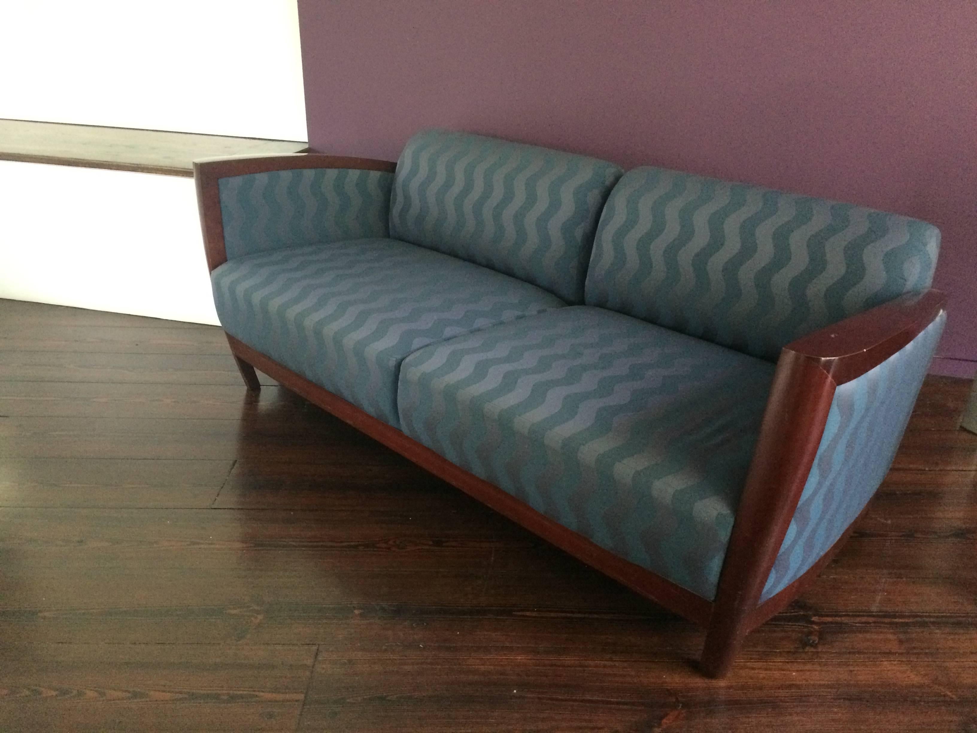 Wonderfully stylish mid-century modern sofa with an art deco silhouette, having super cool wave pattern upholstery in two shades of teal blue. Cushions are not removable.  
 By Kenneth Winslow, NYC.  Measures: Arm height 27, seat depth 25.