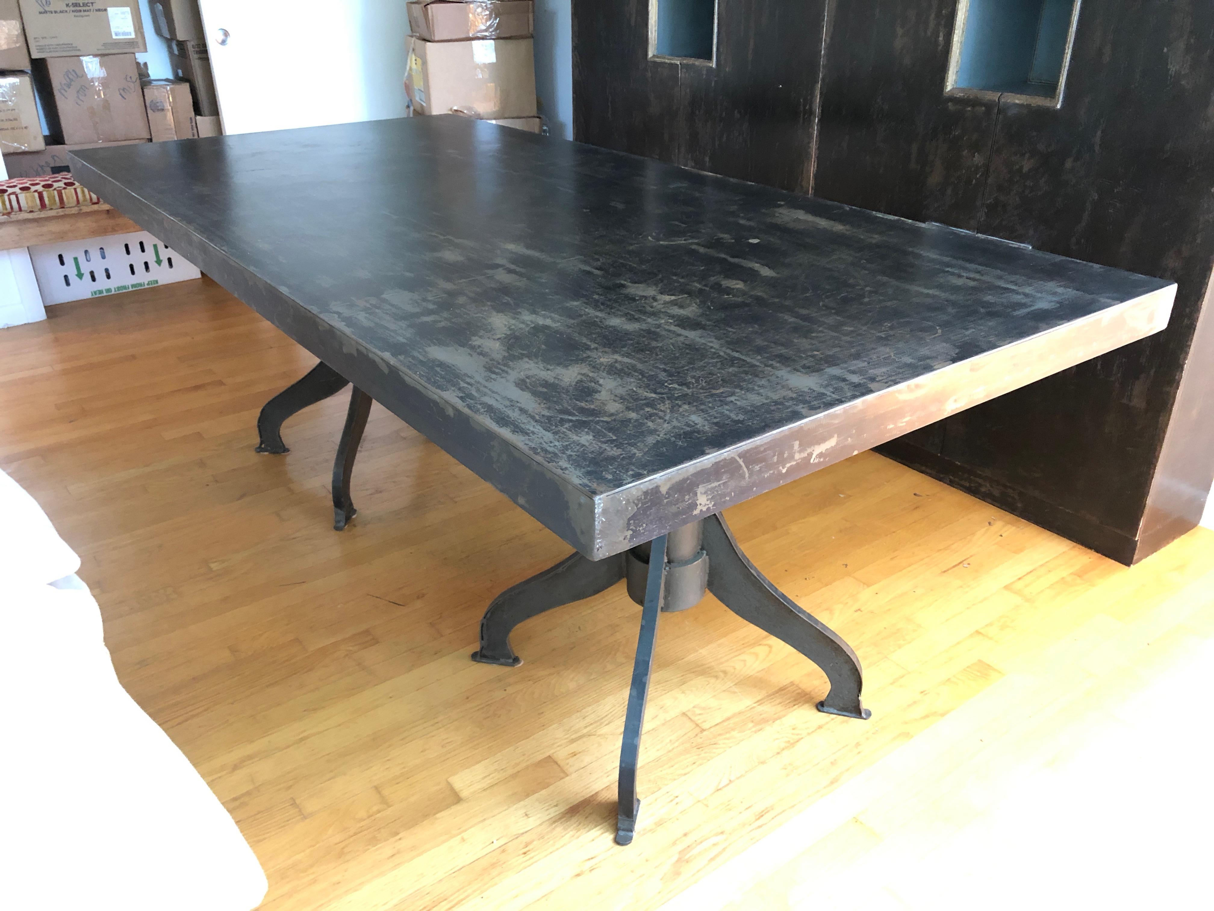 Stunning heavy gauge sheet steel table with distressed surface and two chunky cast iron column bases having four 