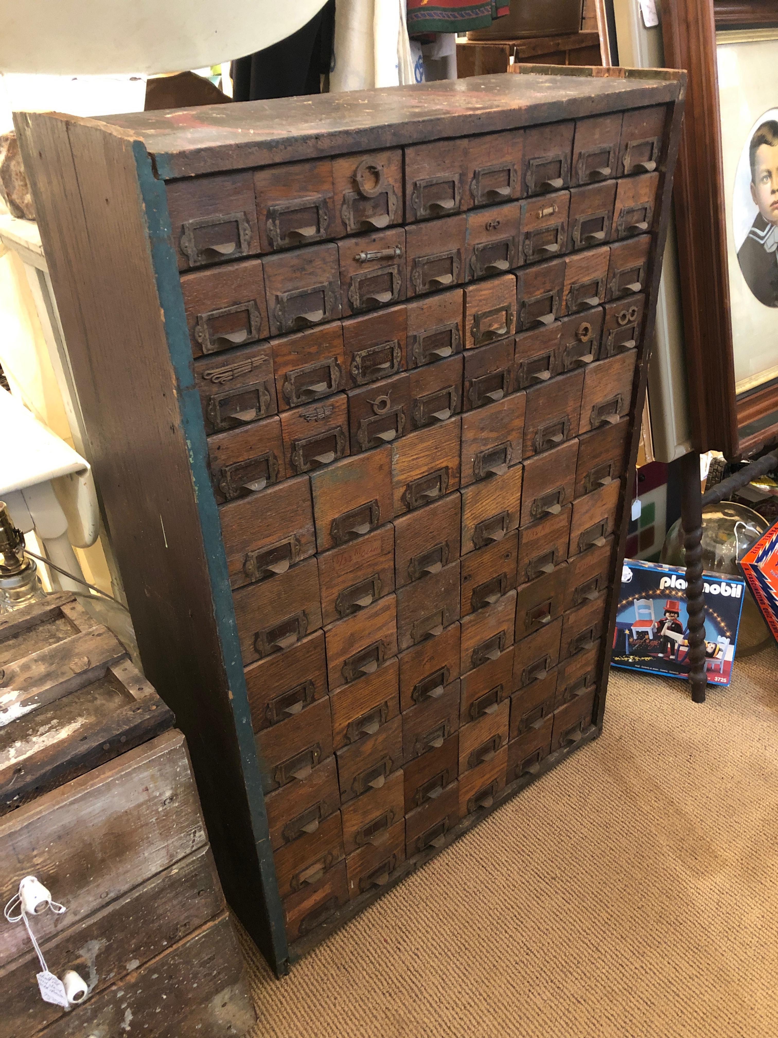 Oozing with character, an authentic 19th century multi drawer hardware storage cabinet having 74 little drawers once used for nails, screws, nuts, etc. The drawers are galvanized steel and the cabinet is aged oak. Some of the original hardware