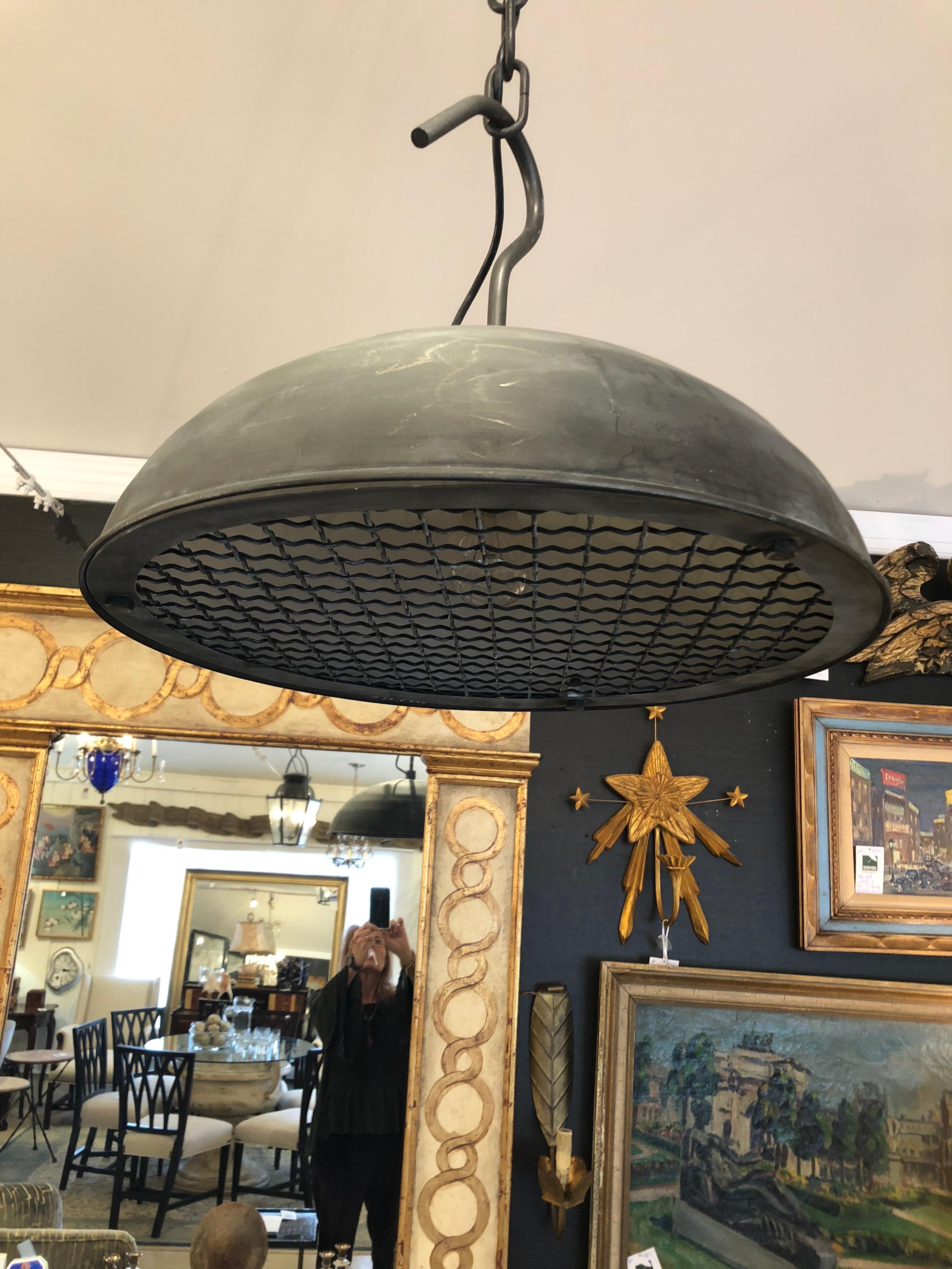 High end lighting company Urban Electric's versatile spin on an industrial warehouse light having a heavy mesh diffuser inspired by salvaged bronze furniture wire. An eye-catching outsized hook and an exposed black cord round out this statement