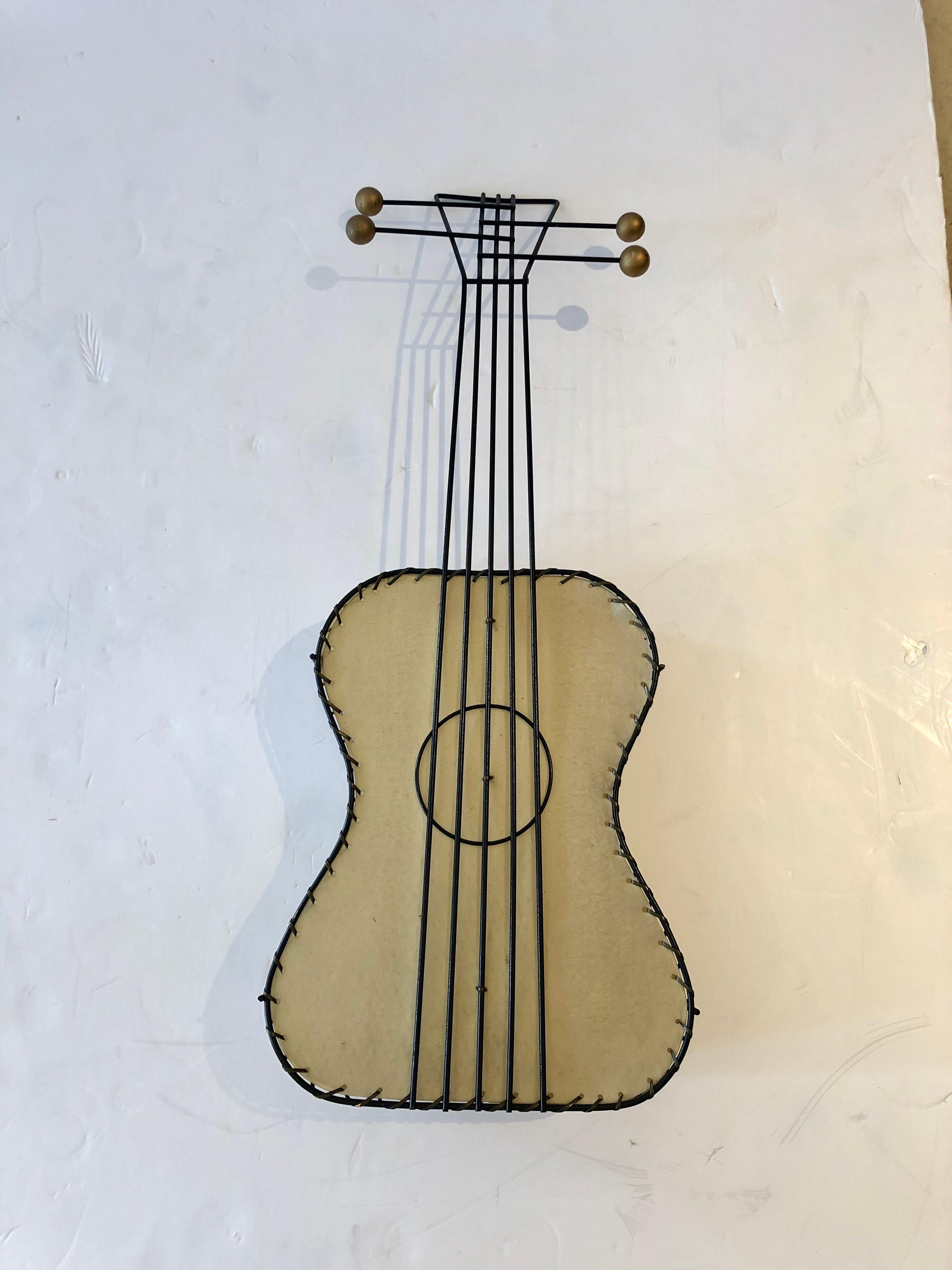 Die Wandleuchte in Form einer stilisierten Gitarre ist ein Sammlerstück von Frederick Weinberg aus Eisen, Messing und gestrecktem Naugahyde aus der Jahrhundertmitte. Eine Glühbirne innen. Sieht toll aus, beleuchtet oder unbeleuchtet. Wie ein Stück