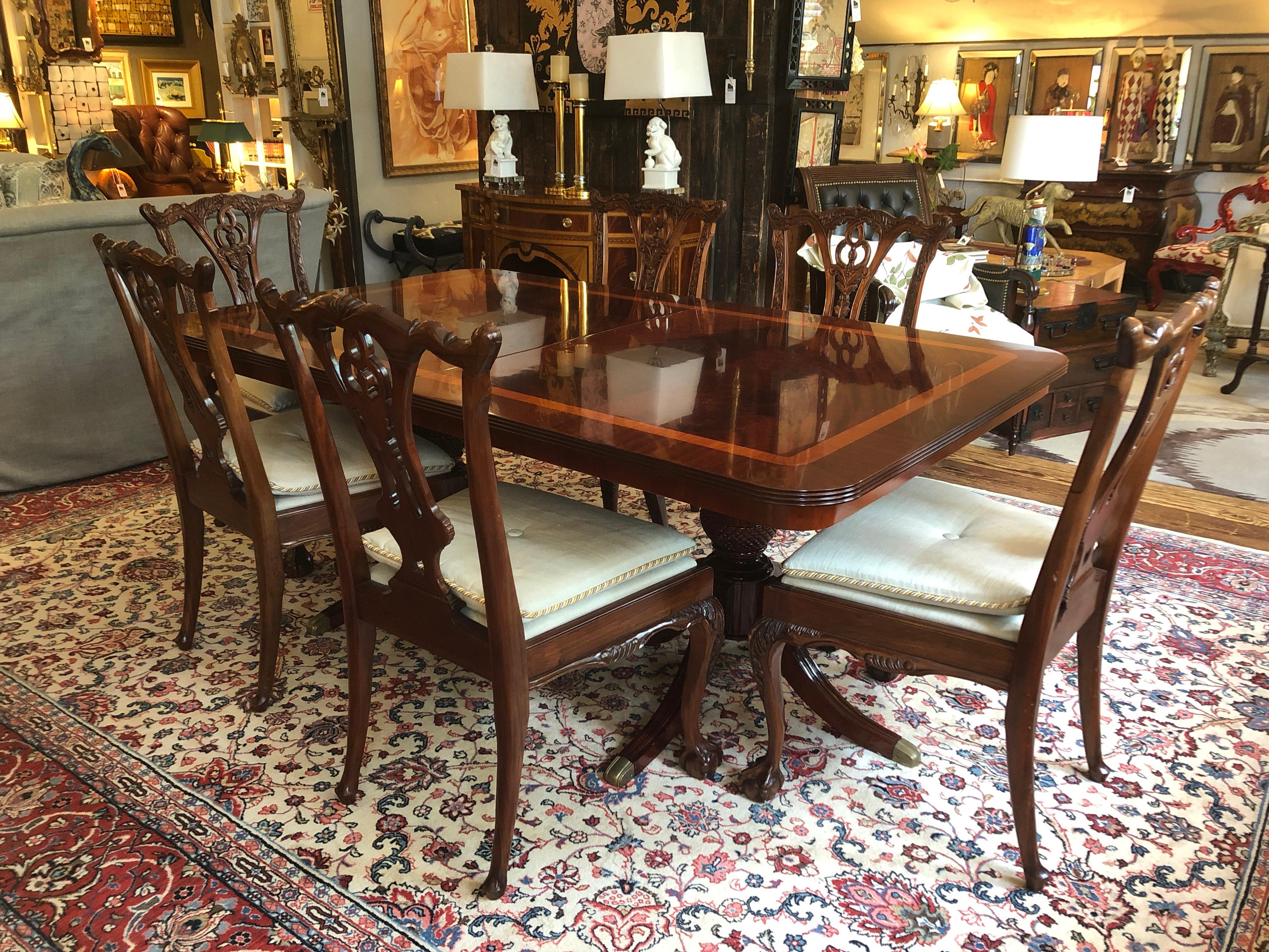 A stately Georgian style double pedestal mahogany dining table featuring a stunning satinwood band inside a cross-banded mahogany edge, with beautiful crotch veneer in the centre of the tabletop. The pedestals have inverted acorn like forms resting