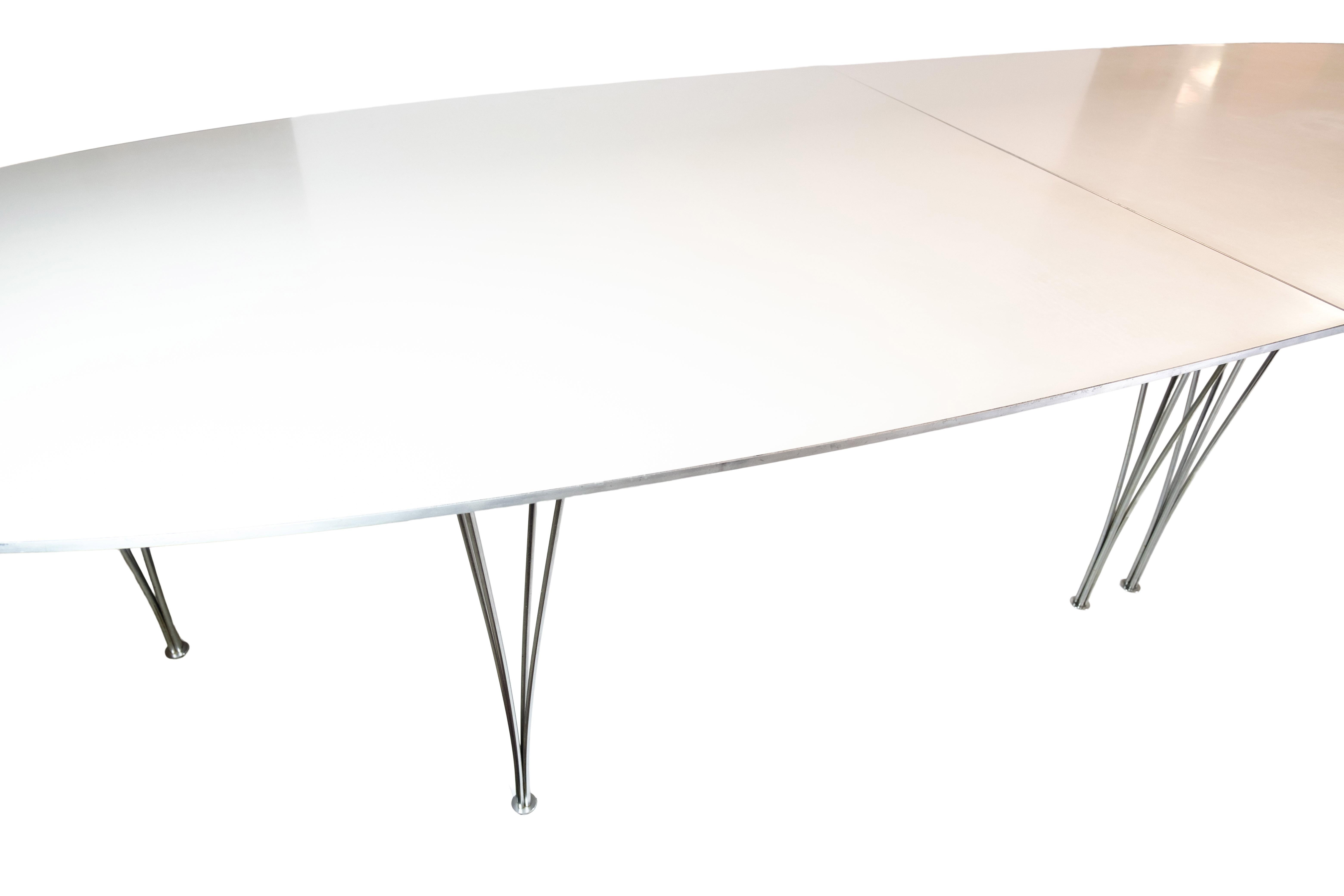  the Super Ellipse conference table, crafted in 1979 by the renowned designers Piet Hein and Bruno Mathsson and manufactured by Fritz Hansen. This stunning table features a sleek white laminate surface with an aluminum edge, exuding a modern and