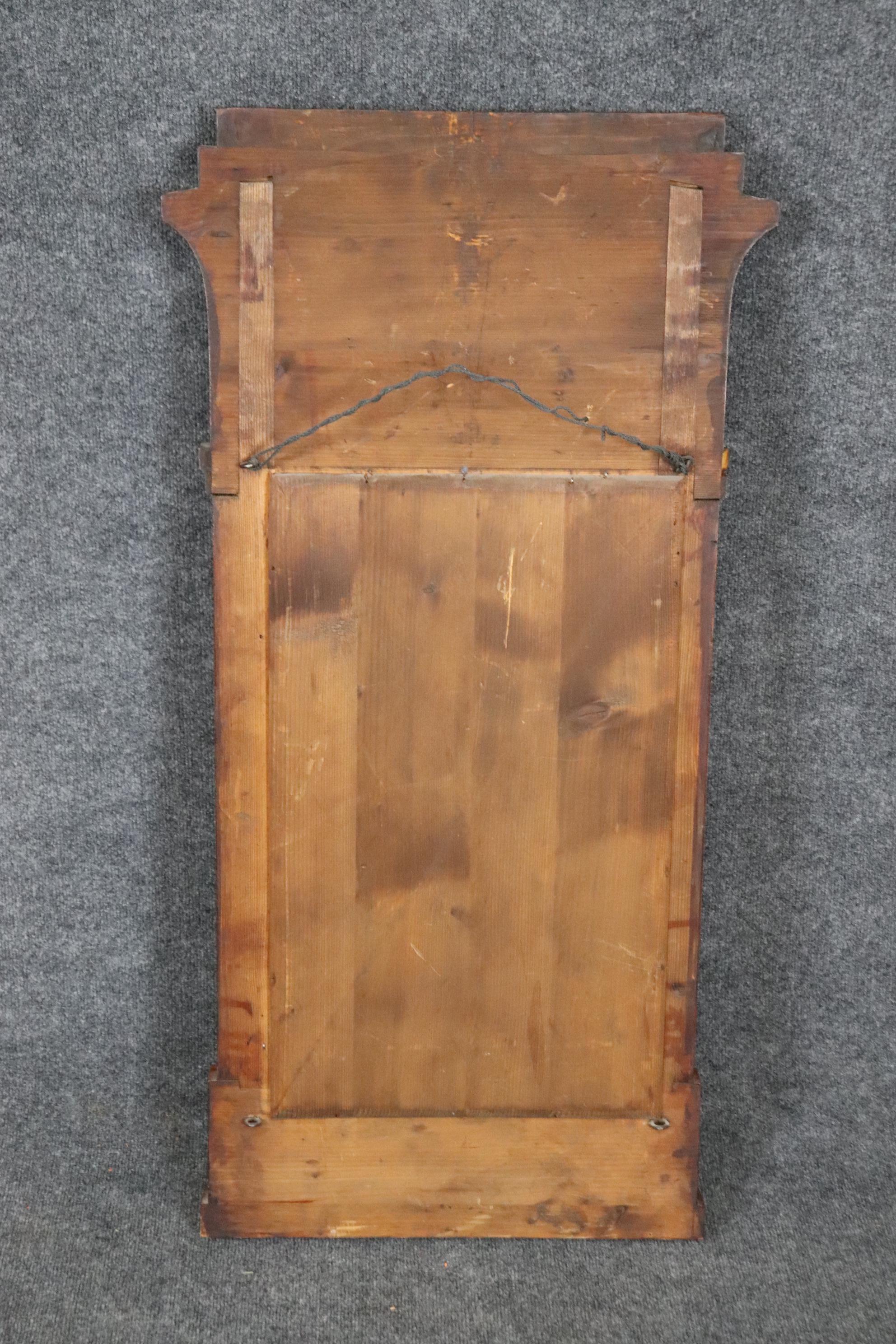 This is a dazzling antique original mirror that is made of gorgeous ash wood and elaborately figured in beautiful wavy grain and in good condition with a beautiful mirror plate mirror. The mirror Measures 43 tall x 22 wide x 2.75 deep and dates to
