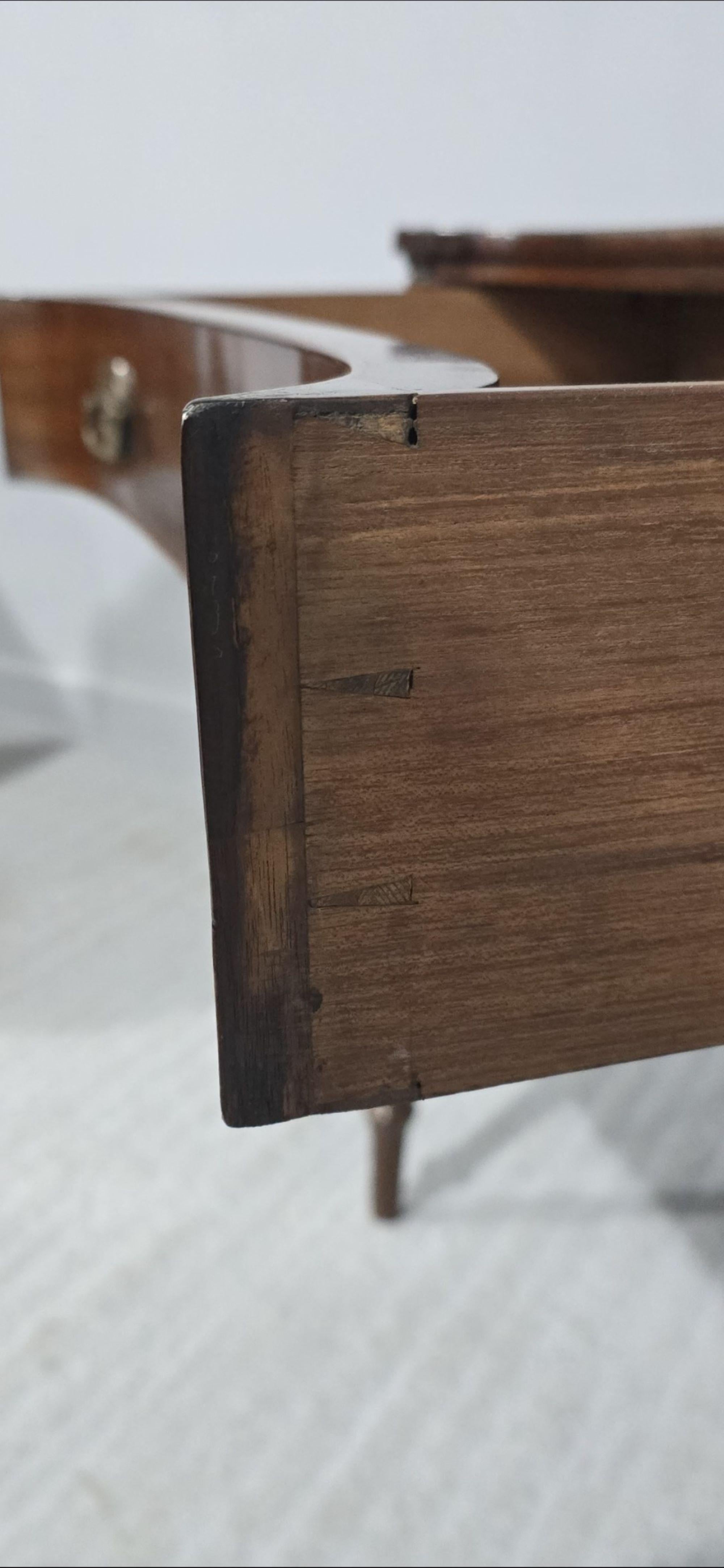 Mesa auxiliar georgiana con incrustaciones de caoba de excelente calidad, con un raro frente cóncavo y un solo cajón completo, patas de caña y torneadas, en excelente estado general original.

31