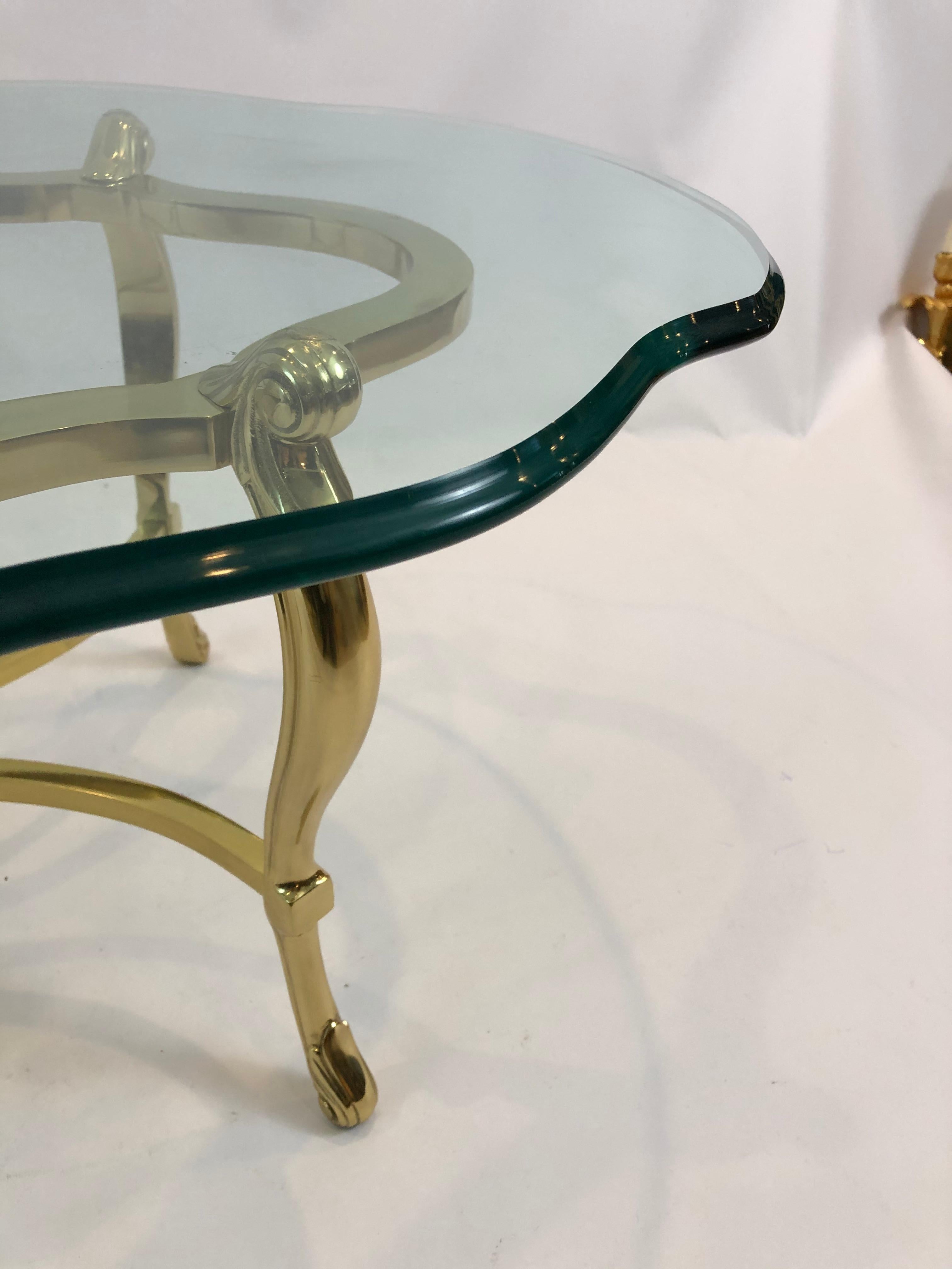 Super glamorous LaBarge coffee table having solid brass oval curvy base with cabriole legs and pretty stretcher, topped with a .75 thick scalloped bevelled edge piece of oval glass.