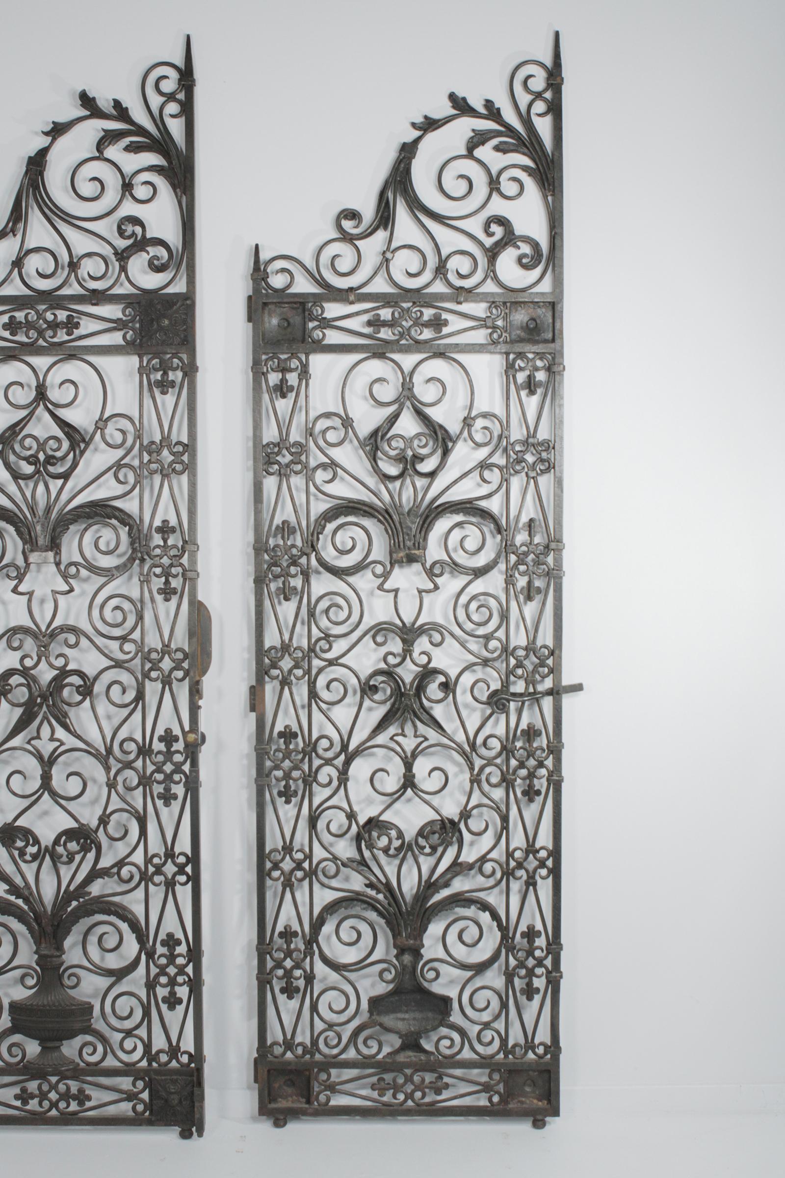 Gorgeous ornate very impressive large European handwrought iron gates having two panels with ornate curlicues in a gun metal color with brass accents. Great as room dividers or architectural doors.
Original hardware for mounting