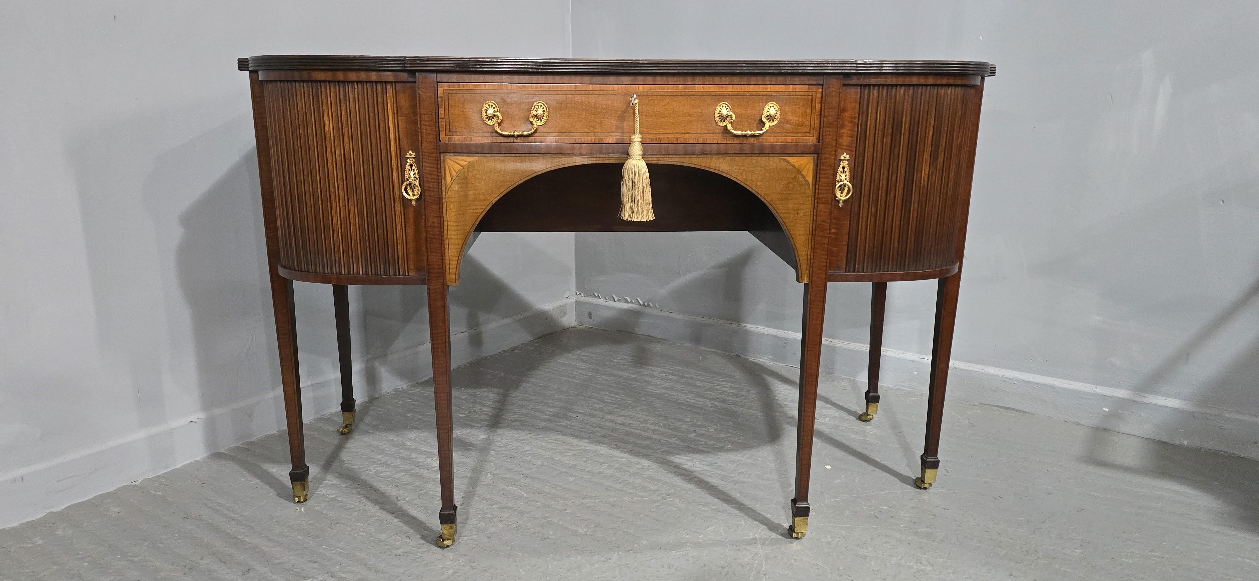Splendida credenza in mogano intarsiato, con splendide maniglie ormolu e un'insolita porta laterale a tamburo, cassetto centrale a tutta larghezza, in ottime condizioni generali di colore e conservazione.

32.5