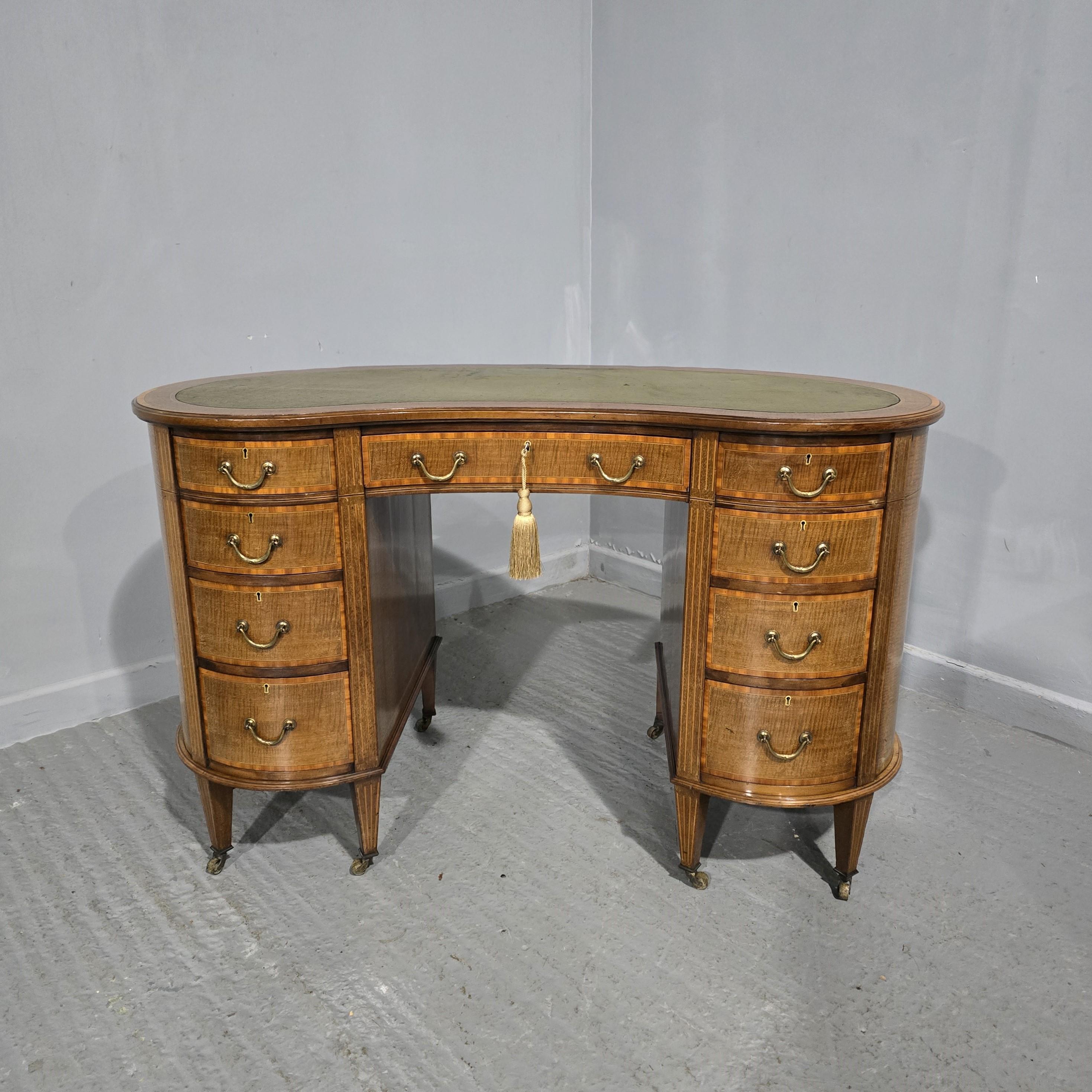 Scrivania a serpentina in mogano massiccio edoardiano di ottima qualità con fasce in legno satinato e piano in pelle verde, maniglie a collo di cigno dorate, serrature funzionanti, nel complesso in ottime condizioni originali.

Altezza