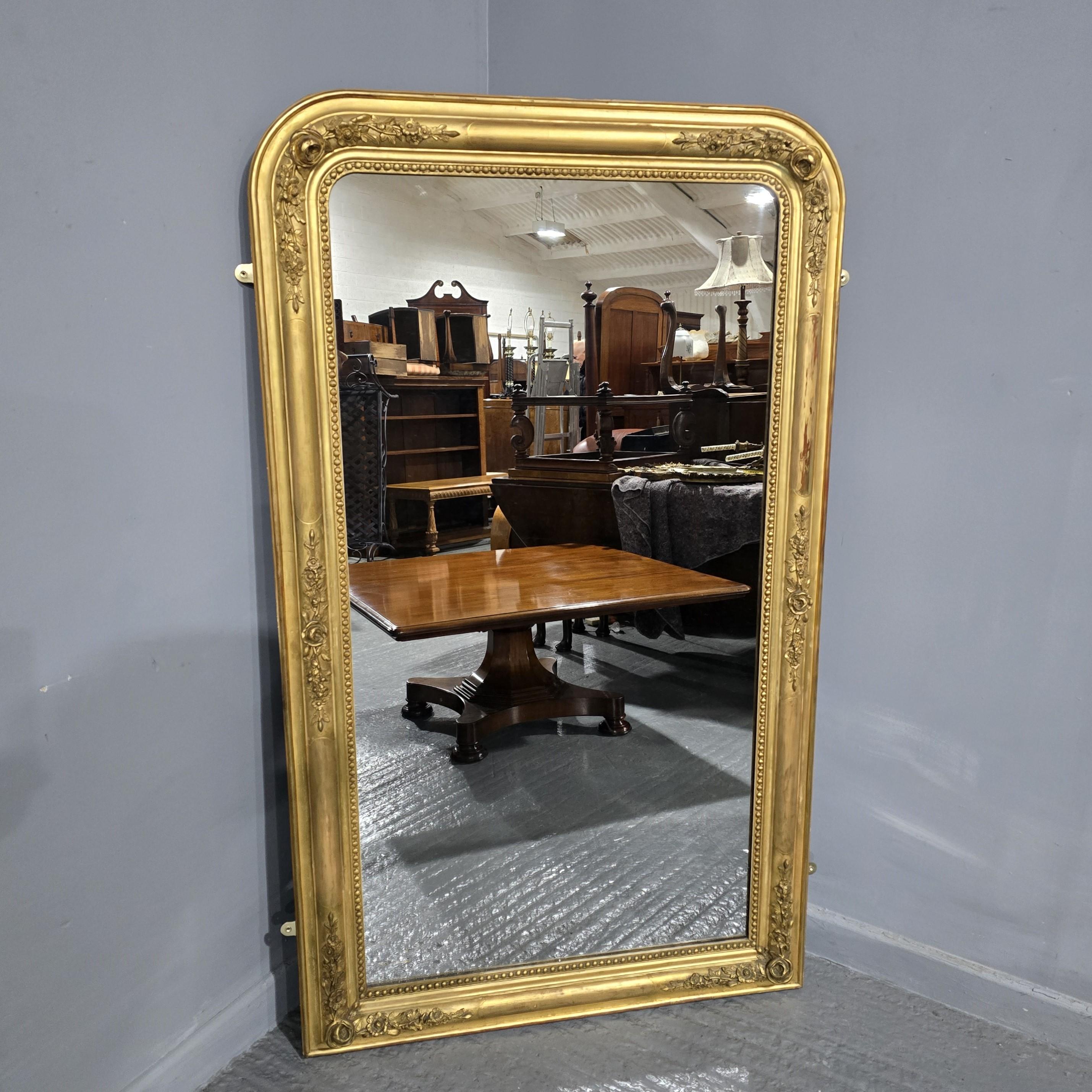 Very attractive mid 19th century antique giltwood wall mirror or console table mirror, having original glass with minor imperfections in beaded and moulded frame decorated with flowery motifs throughout. This antique mirror retains its original