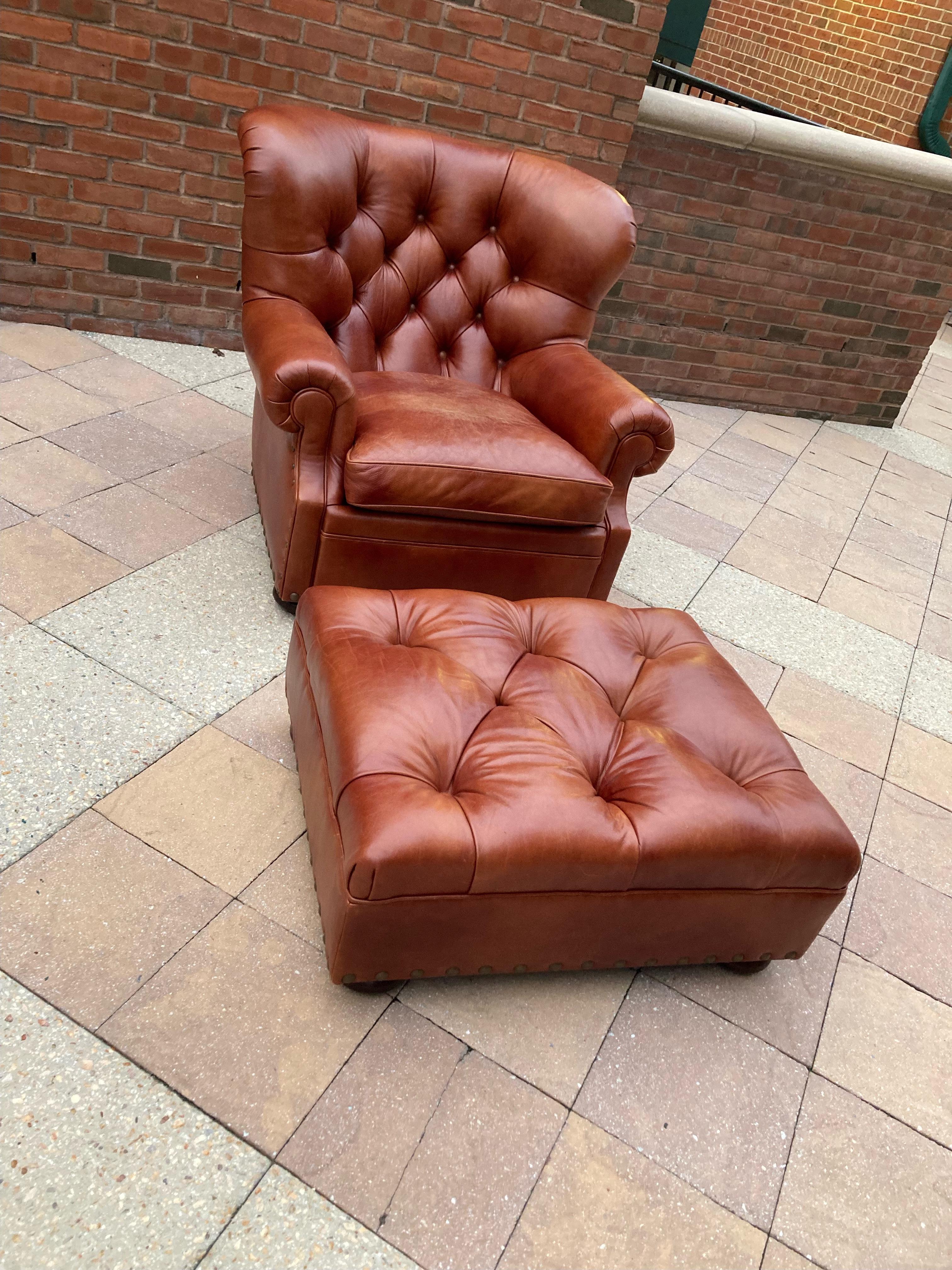 Classic and handsome tufted leather Writer's club chair and matching ottoman having mahogany bun feet and nailhead trim. Super comfy and inviting. Measures: Chair: 41 W x 41 D x 36 H Arm height 22 Arm width 8 Between arms 21 Sitting depth 25 Ottoman
