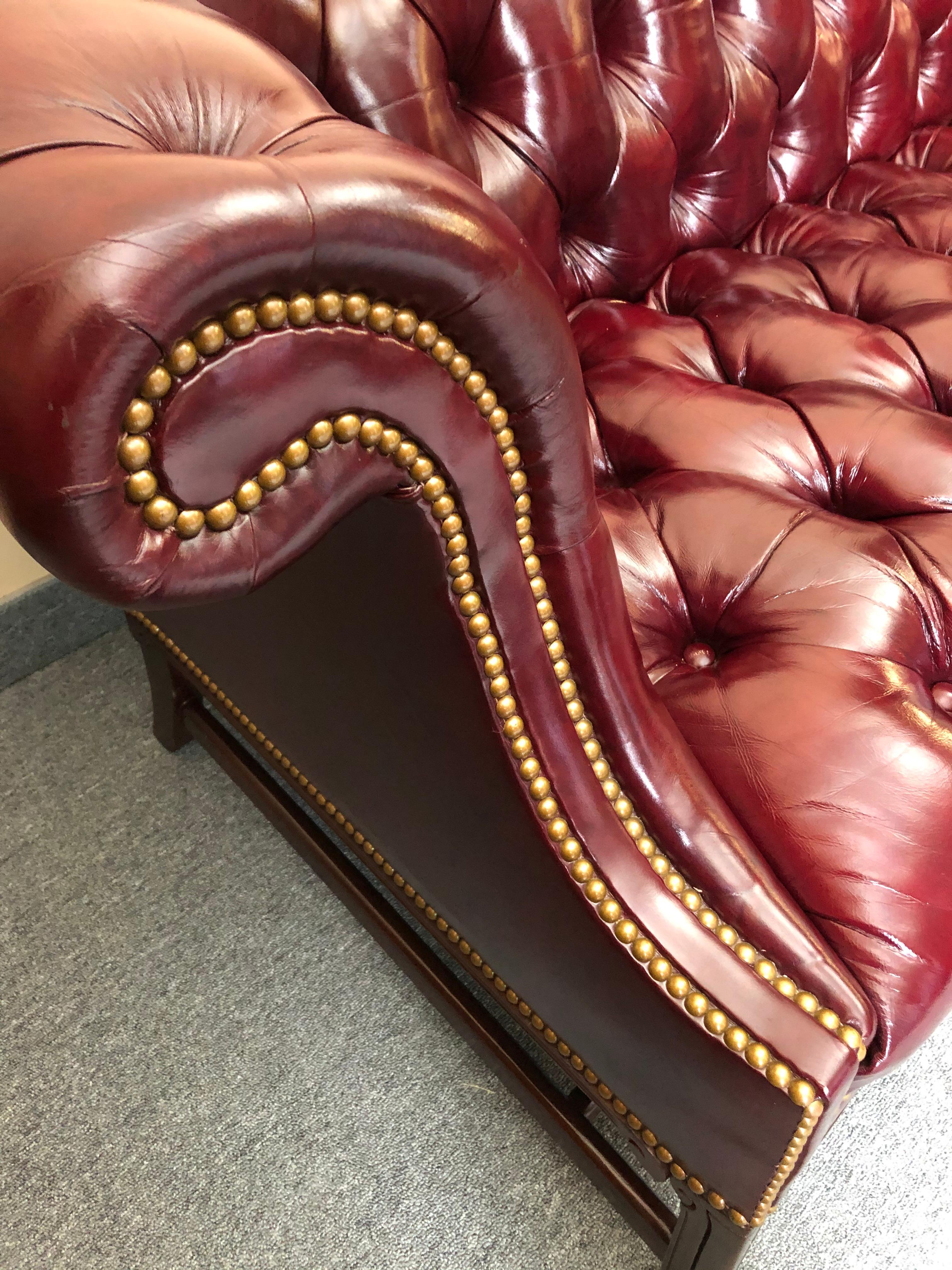 Sumptuous traditional camelback Chesterfield style sofa having supple rich deep maroon tufted leather, brass nailhead detailing, and mahogany legs. Very comfortable and Classic.
Measure: Seat depth 21
Arm height 30.