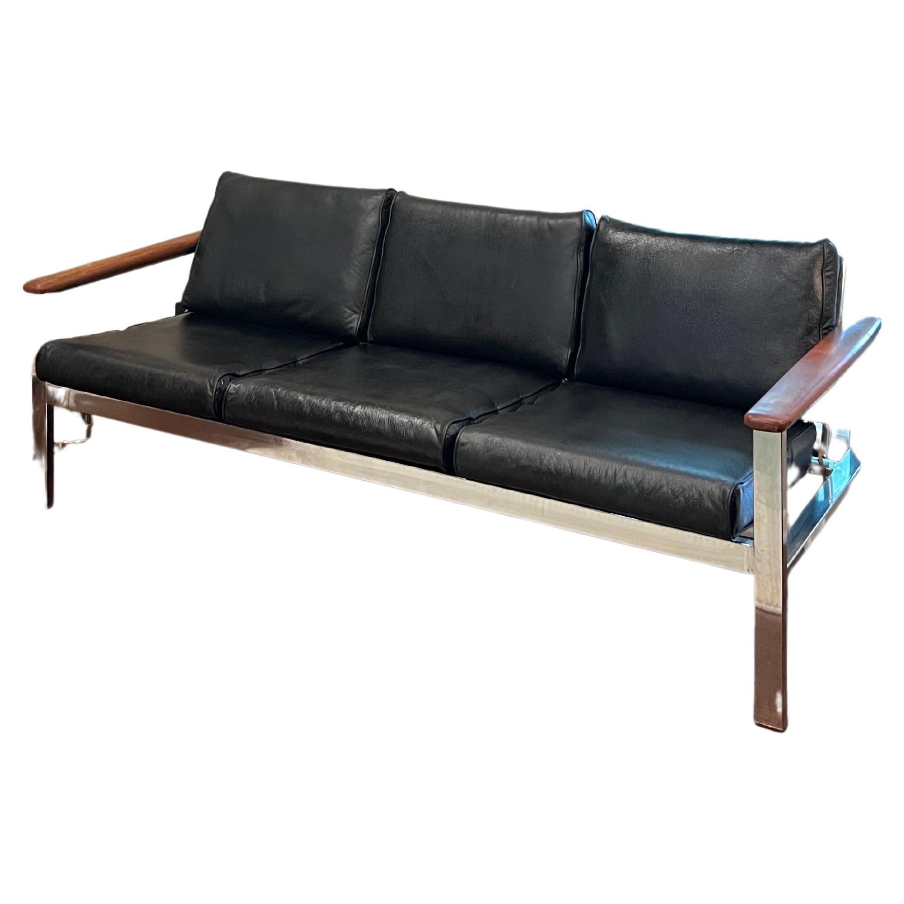 Super rare vintage sofa by Samsonite made in the 1970s. With a chrome body, and wood grained arm rests, this 3 seater sofa is a show stopper. The black material is made of vinyl, and is in fair condition with one tear as seen in photos. I flipped