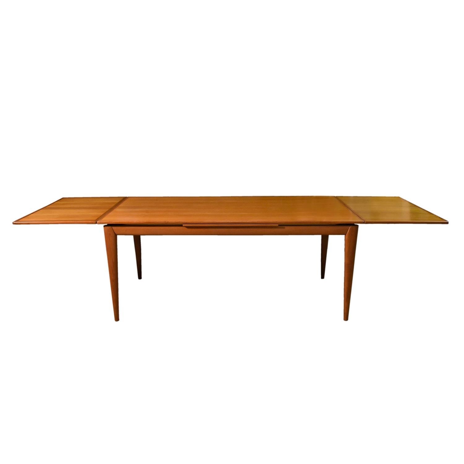 Massive draw leaf Danish teak dining table, circa 1960s. This model is the BIG BOY at just under 10 feet fully extended. Designed by Niels Otto Møller for J.L. Møllers Møbelfabrik, this hefty beauty boasts solid teak tapered legs and gorgeous edge