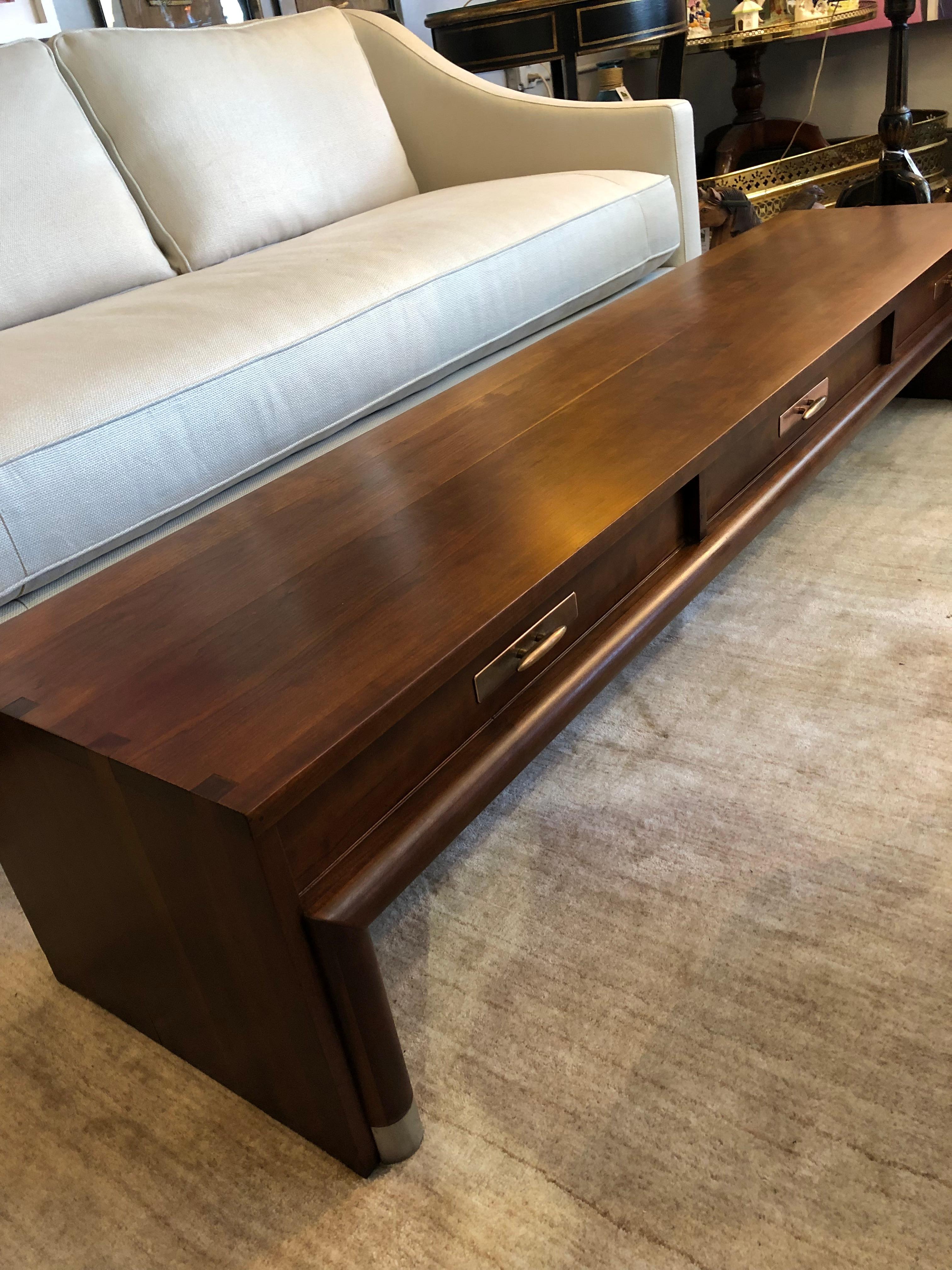 Super chic low slung and very long cherry cocktail table having 3 drawers on one side and stylish copper patina hardware. Gorgeous grain and lustre makes this glamorous piece a focal point.