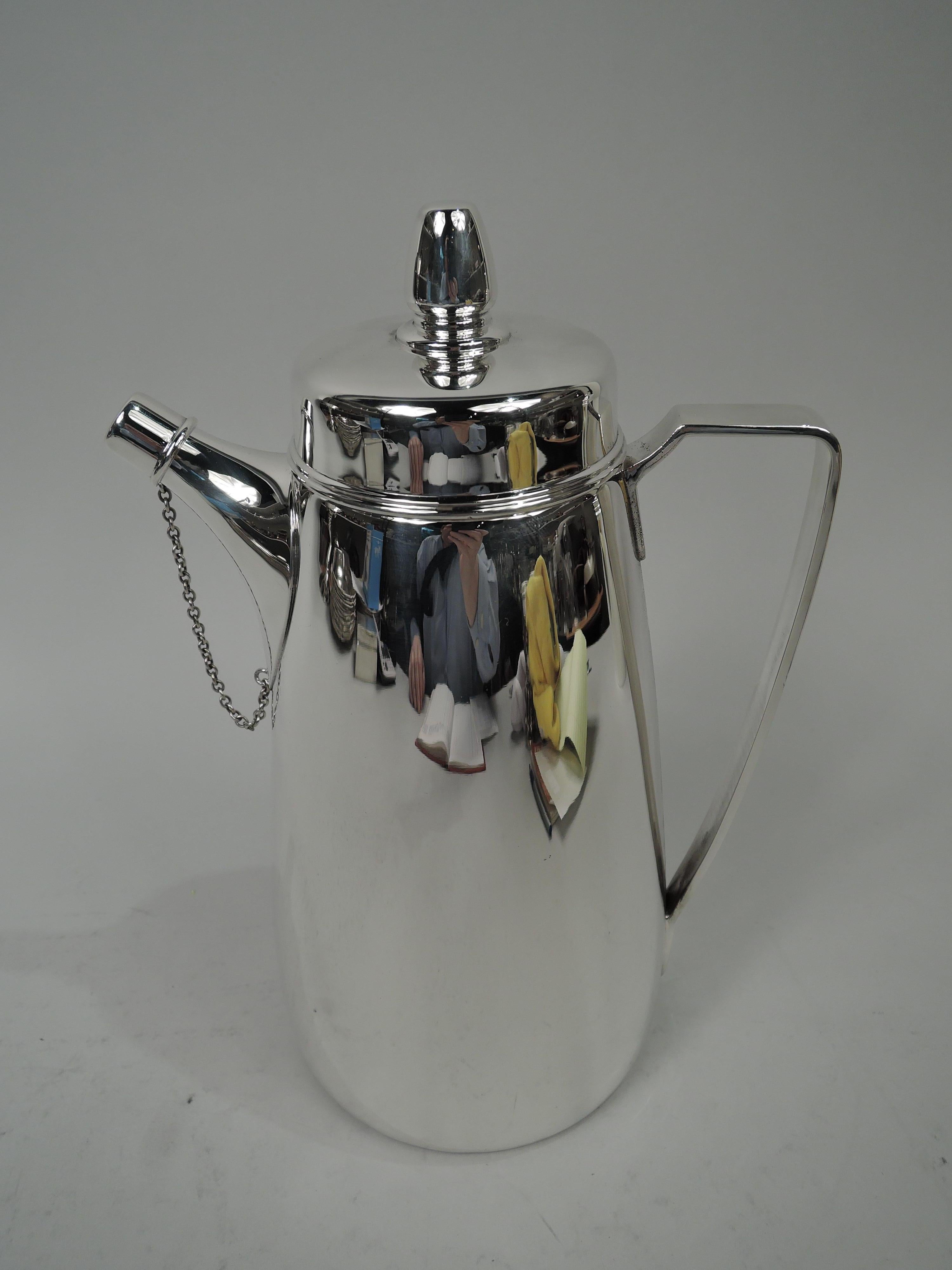 Super snazzy sterling silver cocktail shaker. Made by Tiffany & Co. in New York, ca 1929. Gently curved and upward tapering sides and flat cover with same-form finial. Bracket handle. Stubby spout with chained cap. Built-in strainer. A late