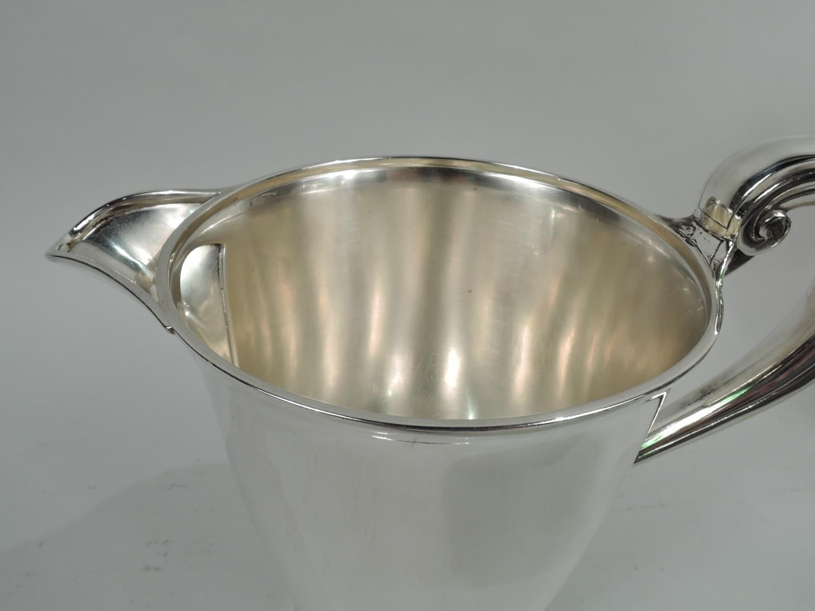 Super stylish Modern sterling silver water pitcher. Made by Tiffany & Co. in New York, ca 1912. Tapering bowl on round and stepped foot. High-looping handle and v-spout with ice guard. Fully marked including maker’s stamp, pattern no. 18214 (first