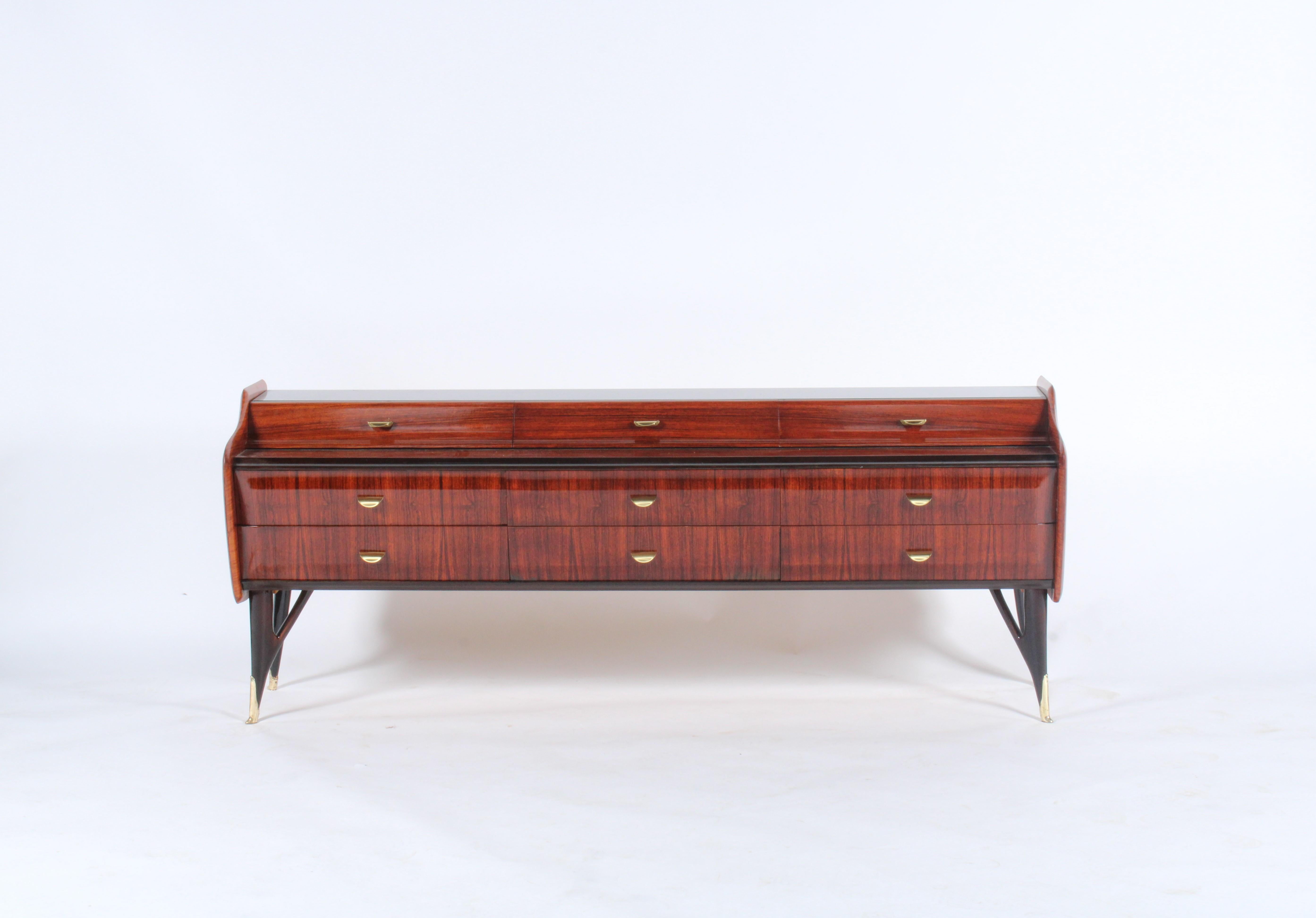 Stunning midcentury Italian sideboard in rosewood with inset glass top,on ebonized sculpted legs with brass detailing. This incredibly stylish piece comes with ample drawer storage and has been professionally restored and refurbished and as such is