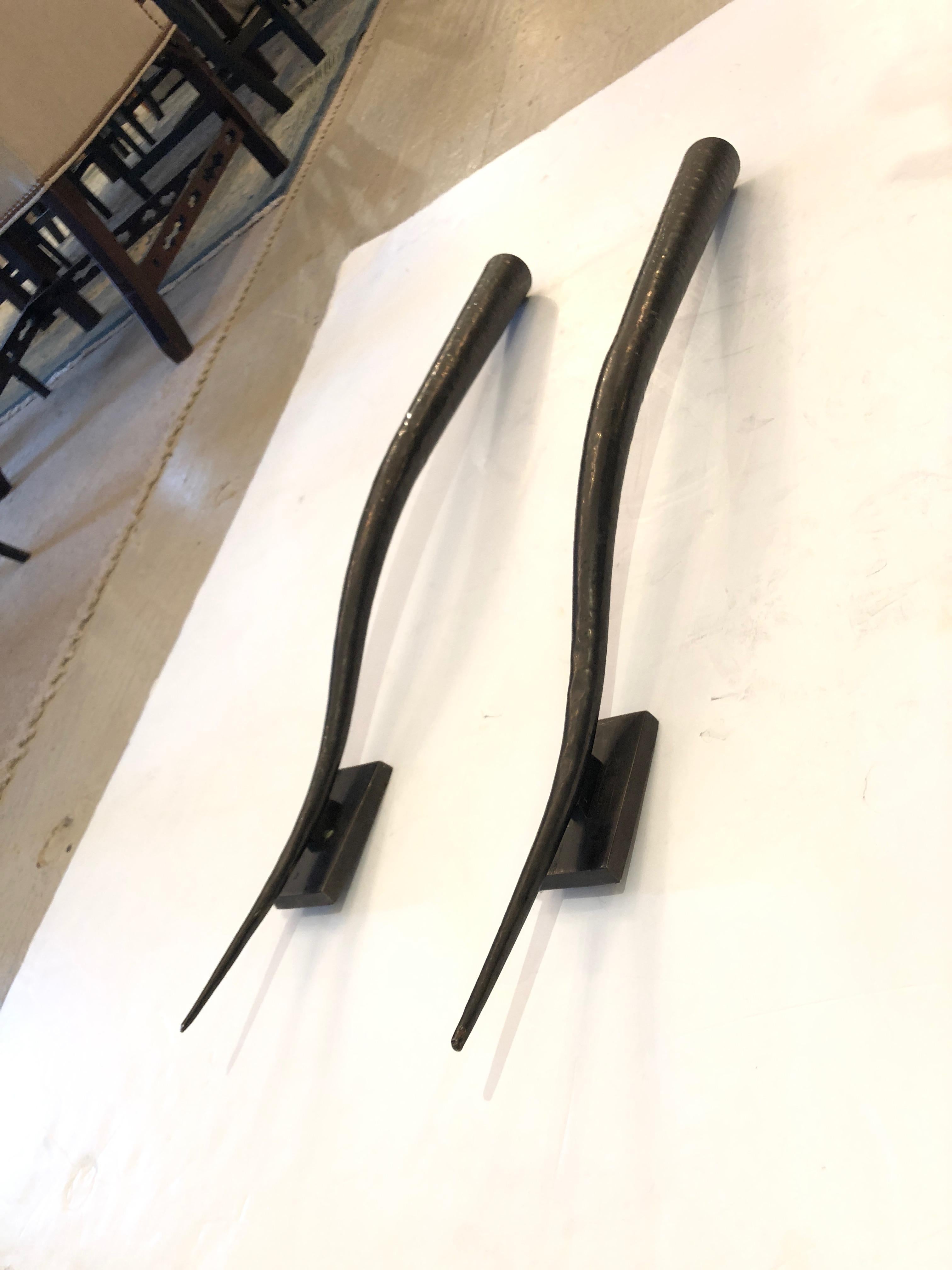Very sophisticated sculptural pair of wall sconces that have an elongated horn or antler shape made out of dark bronze. They are meant to hold candles, but look like sculpture as they are. Could be electrified. Project 5 inches from the wall.