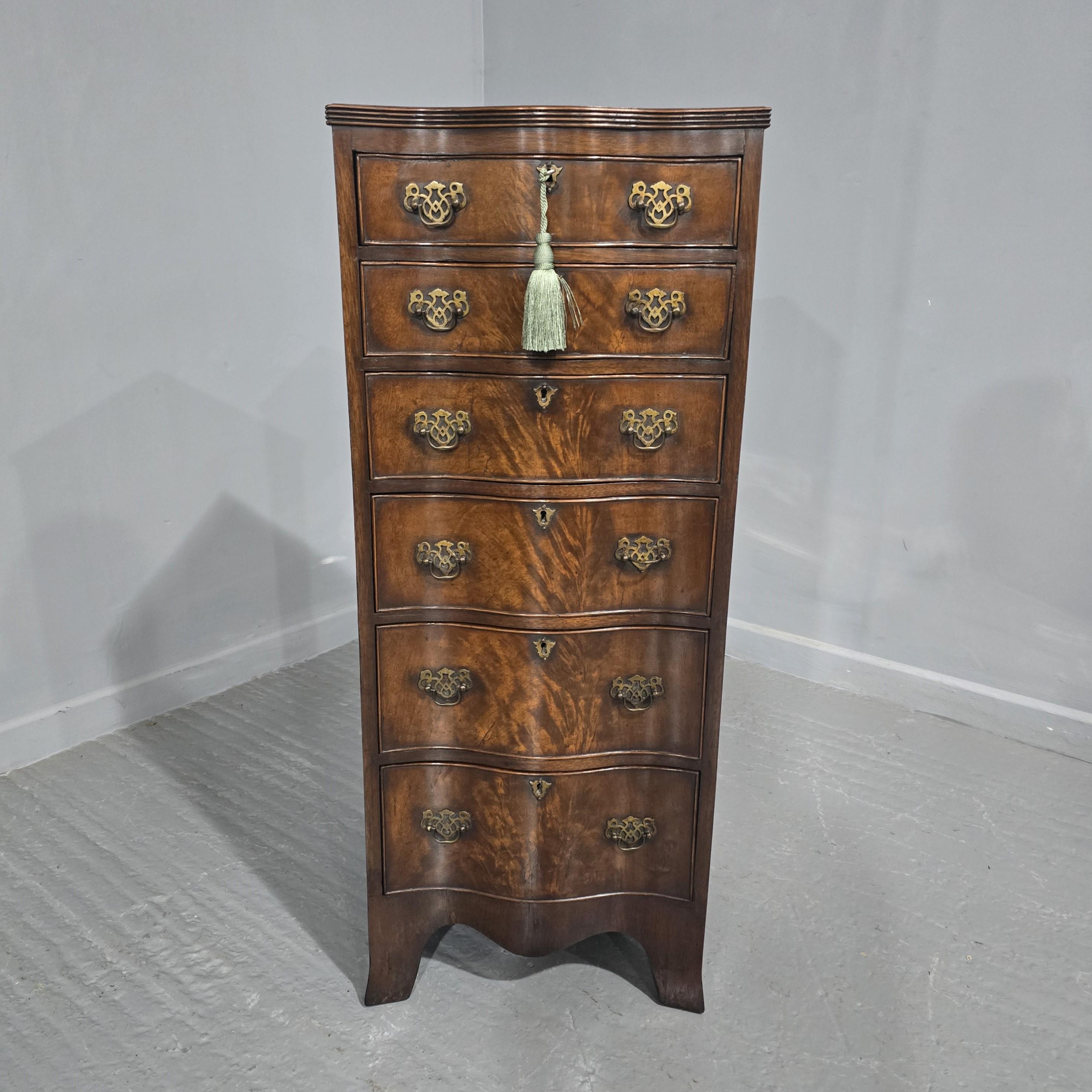 A super deep serpentine flame mahogany tall chest of six drawers, oak lined with brass handles and standing on outswept bracket feet, excellent colour and overall condition.

45.5
