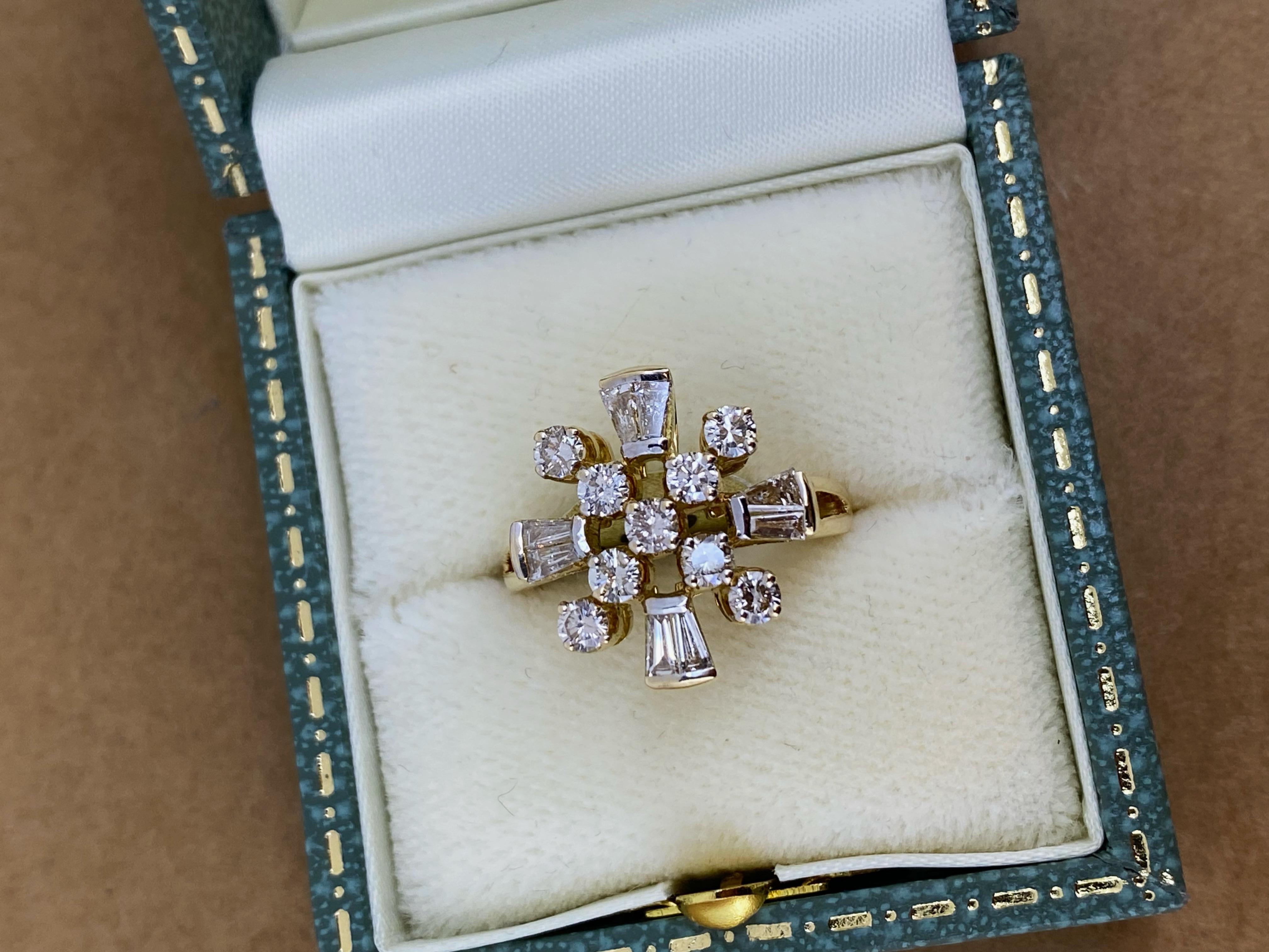 Di grande impatto visivo e che ricorda un famoso designer, questo superbo anello è realizzato in oro giallo 18 carati.
con una notevole attenzione ai dettagli:

Progettato come una testa di fiore, 
al centro di un gruppo incrociato di 
9 diamanti