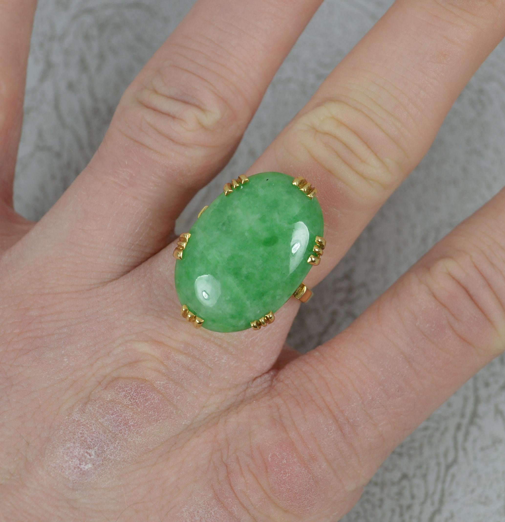A superb Jade solitaire statement ring.
Solid 18 carat yellow gold example.
Designed with a single, oval shaped natural jade in multi claw setting. A large single stone.
16mm x 24mm cluster head. Protruding 8mm off the finger.

CONDITION ;