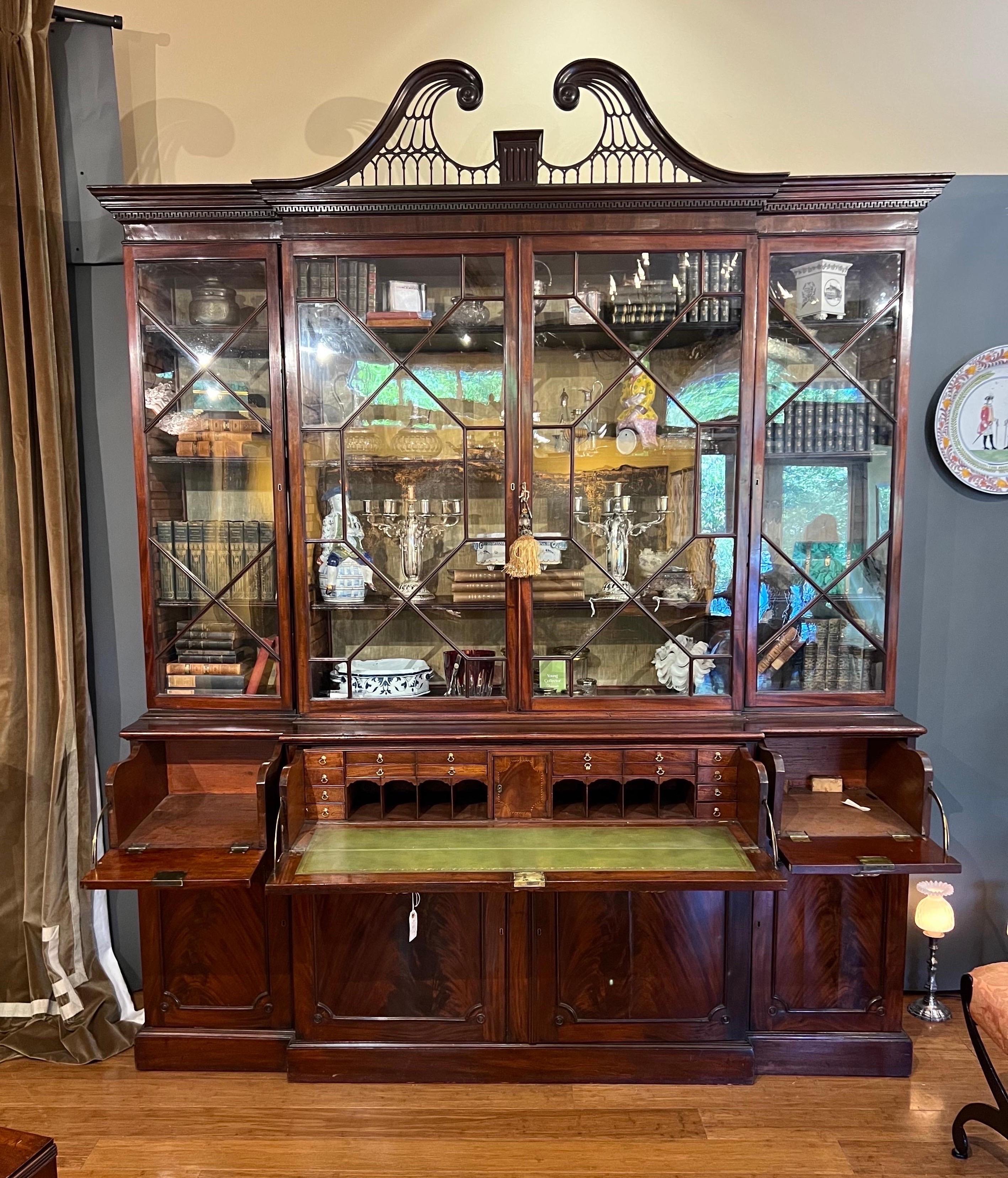 Superb 18th century Georgian Mahogany Breakfront Secretary Bookcase. This incredible secretary has highly figured mahogany, an intricate secretary desk with hidden compartment, beautifully carved swans neck pediment with dentil molding and original