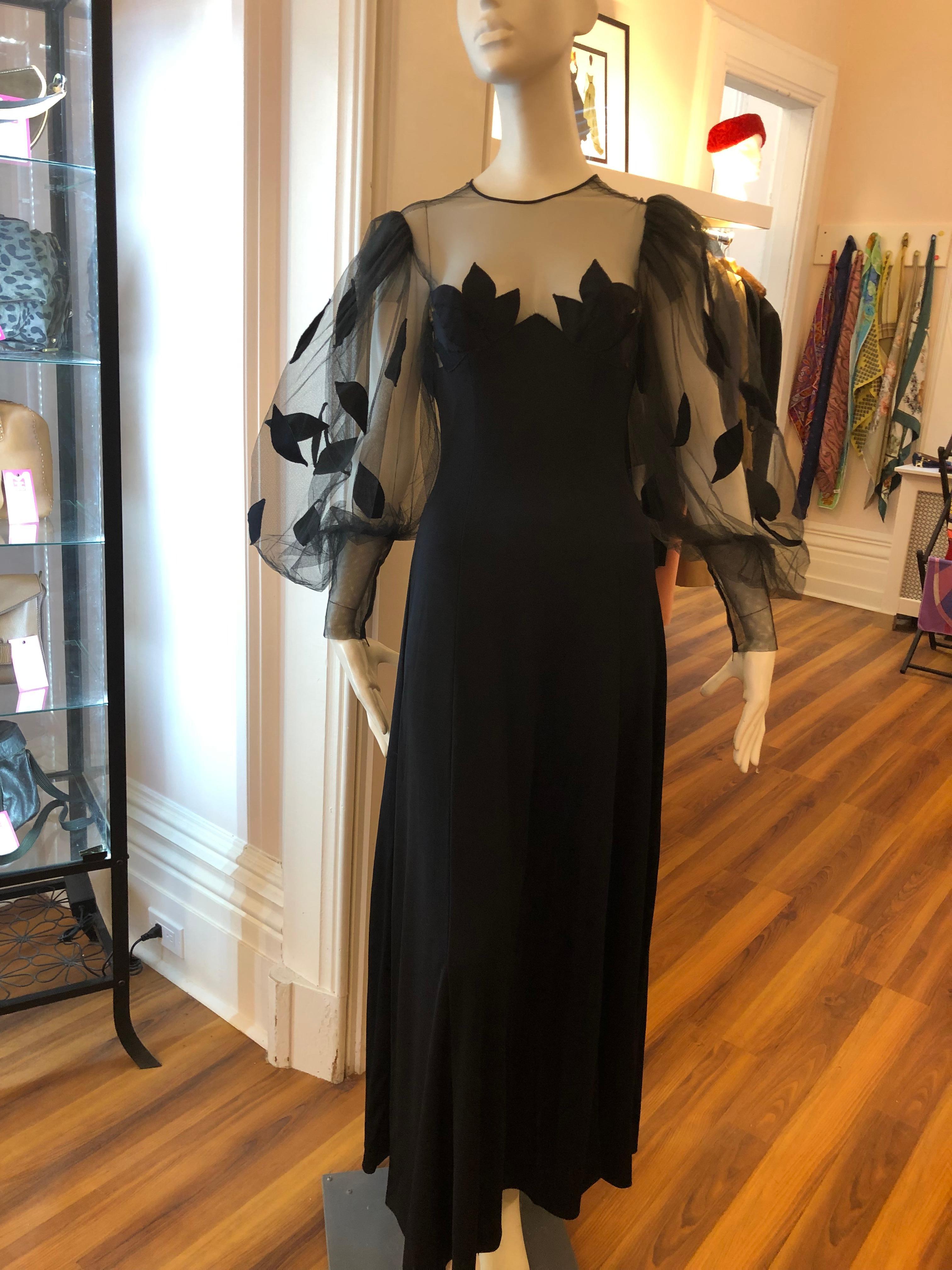 This black Loris Azzaro vintage gown has wonderful detail from the stretch jersey to the net with applique, and the balloon sleeves narrowing to the cuffs which are zippered.

The back is net sheer to under the bust line and has a discreet zipper