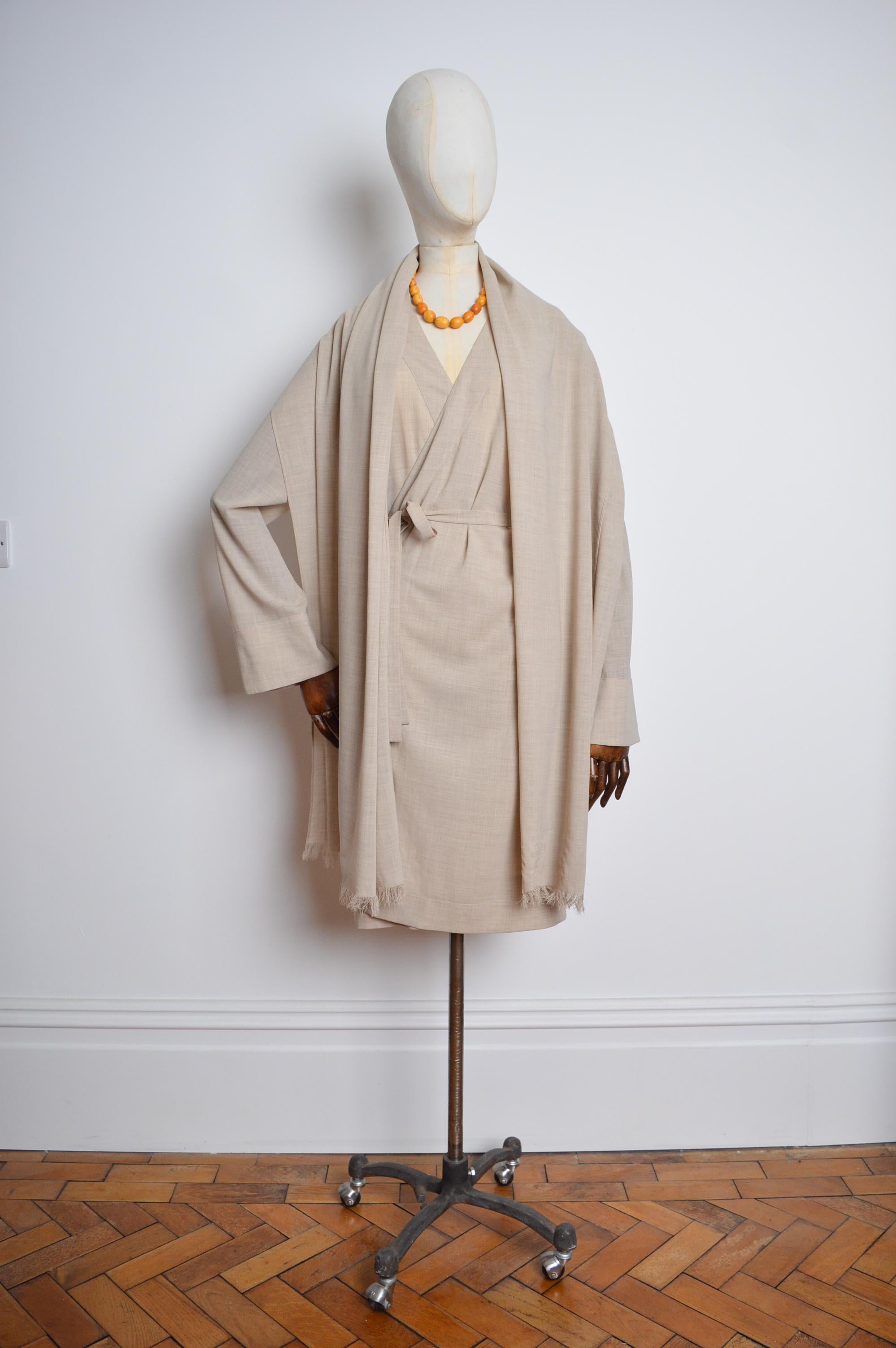 Beautiful Vintage sand coloured Jean Paul Gaultier multi way Wrap Dress - Tunic Coat, circa 1990. 

This beautiful, multiway wrap garment is crafted from a fine natural wool in a sandstone colour, featuring a wrap around cache-coeur structure, long
