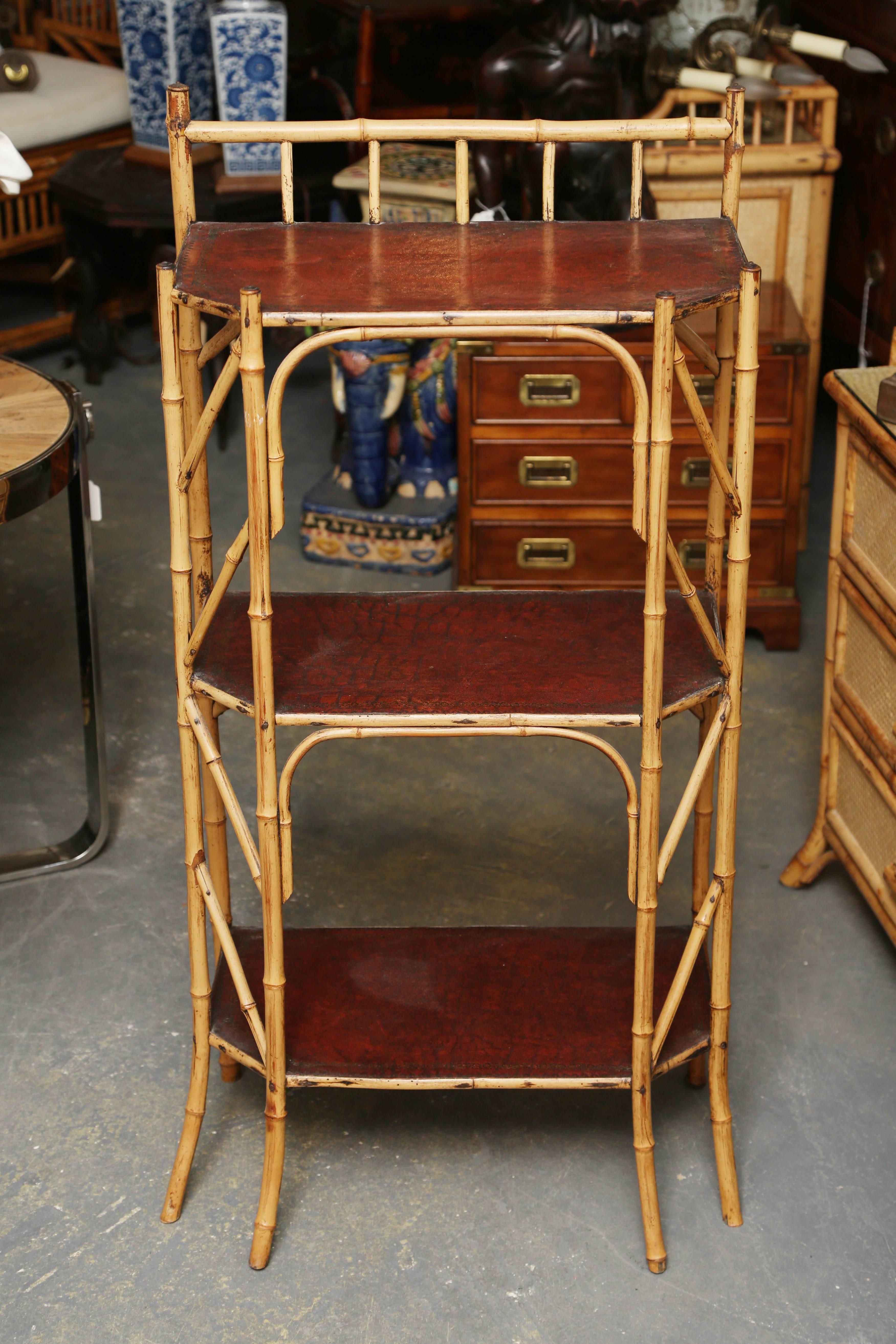 An unusual and fine Edwardian stand with delicate form and embossed leather clad shelves.
