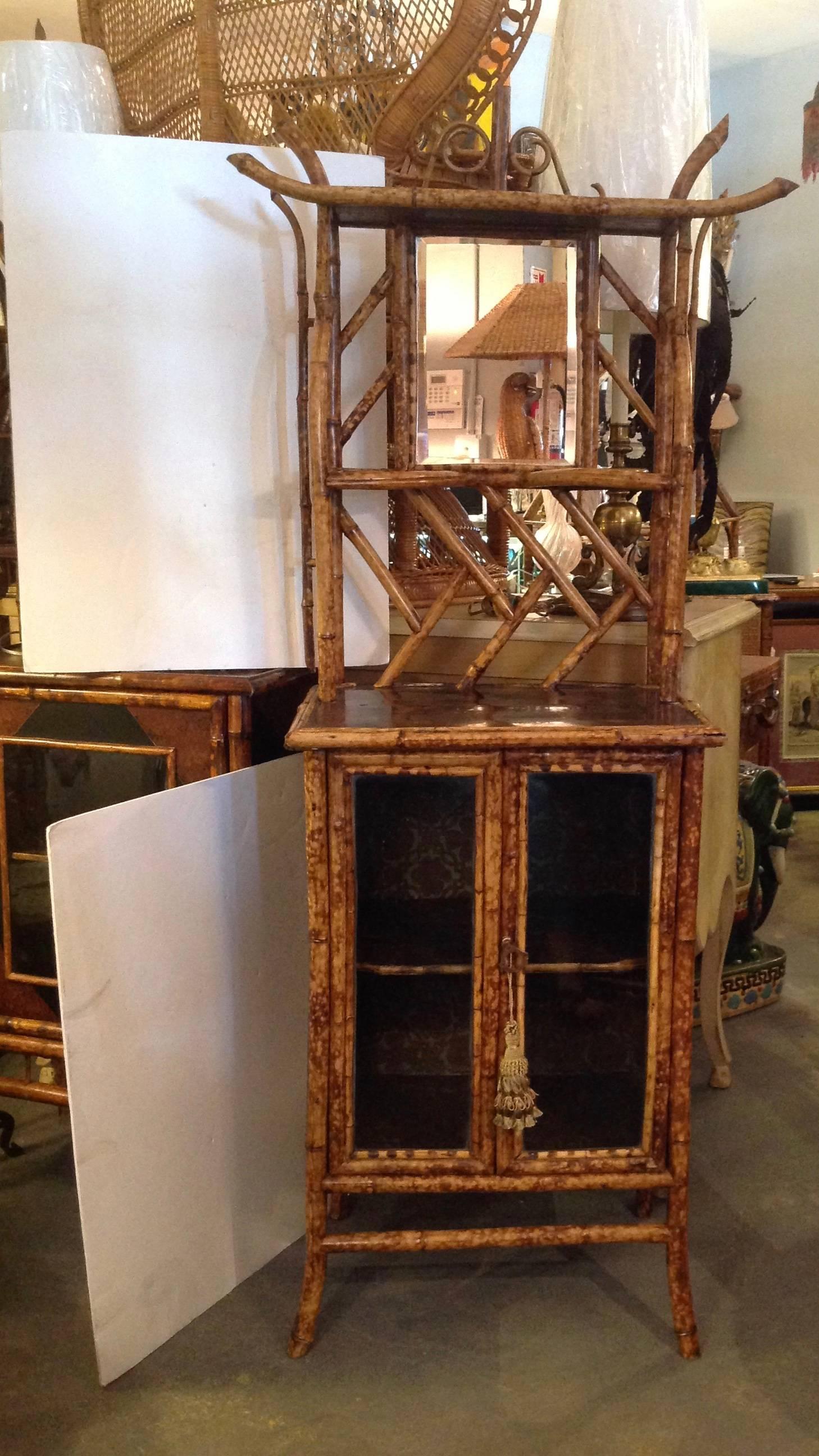 The cabinet is fitted with ample storage for large books.
It is appointed with an elaborate étagère top and mirror.