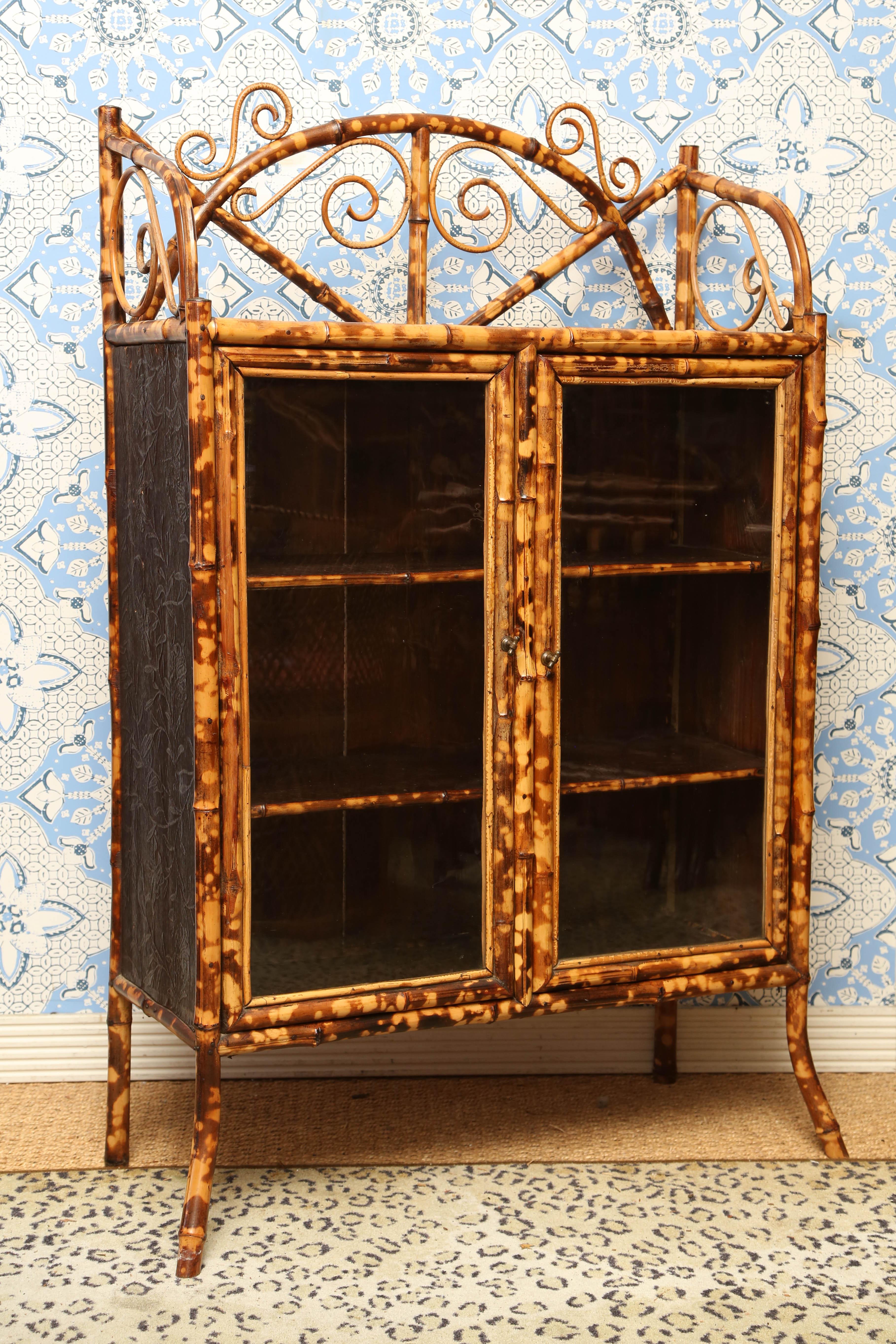 Superb 19th English Bamboo cabinet with two doors glass, with leather paper inside and out and japanning on top.