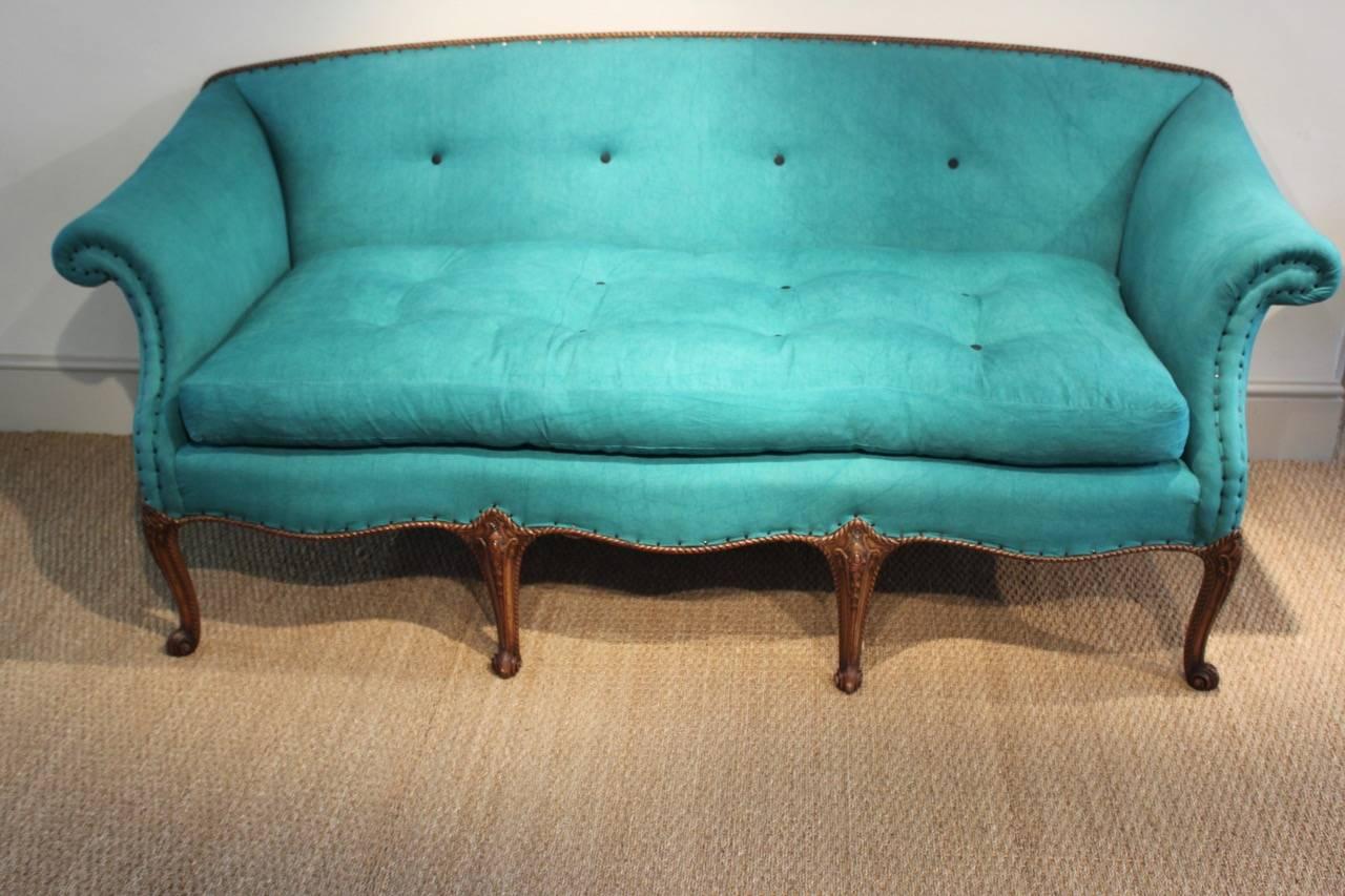 A wonderful quality, and with a lovely shape, 19th century English, eight-legged carved mahogany sofa of serpentine shape, in the Chippendale taste, having been reupholstered by us in a 19th century hand-dyed green linen with contrasting buttons.