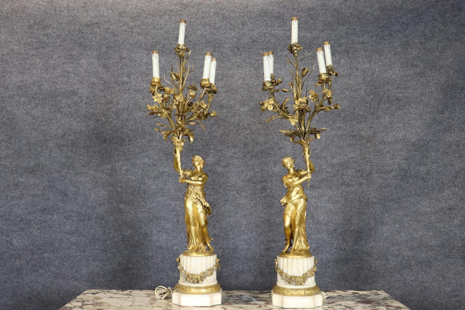 Presentamos un magnífico candelabro de doncella figurado de bronce dorado y mármol del siglo XIX, un opulento ejemplo del arte neoclásico y la excelencia decorativa francesa. Esta pieza escultórica de iluminación, que mide unas impresionantes 40