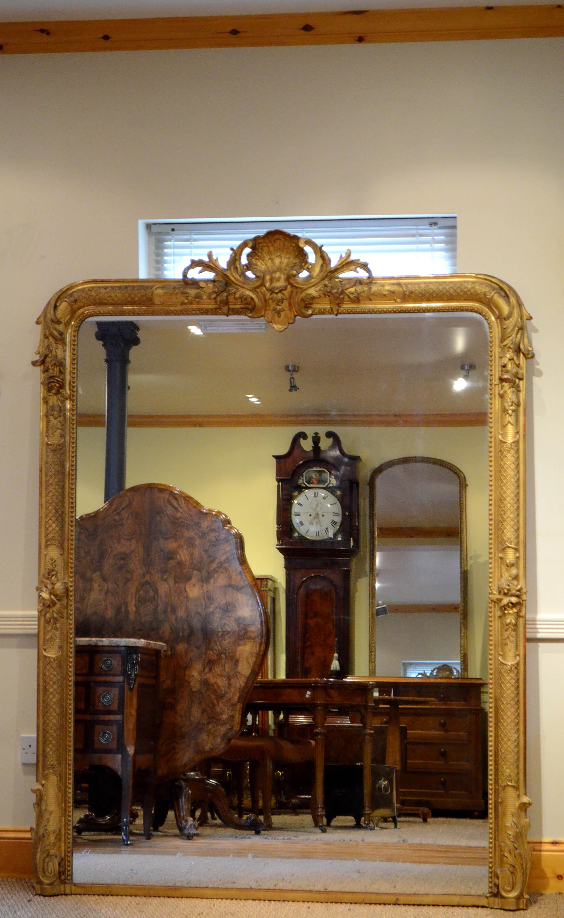 Sn4644, exceptional 19th century mirror of versatile form (can be hung on the wall or stood on the floor), having original glass with some foxing in flower and shell carved gilded frame. This antique mirror retains its original glass, original gilt