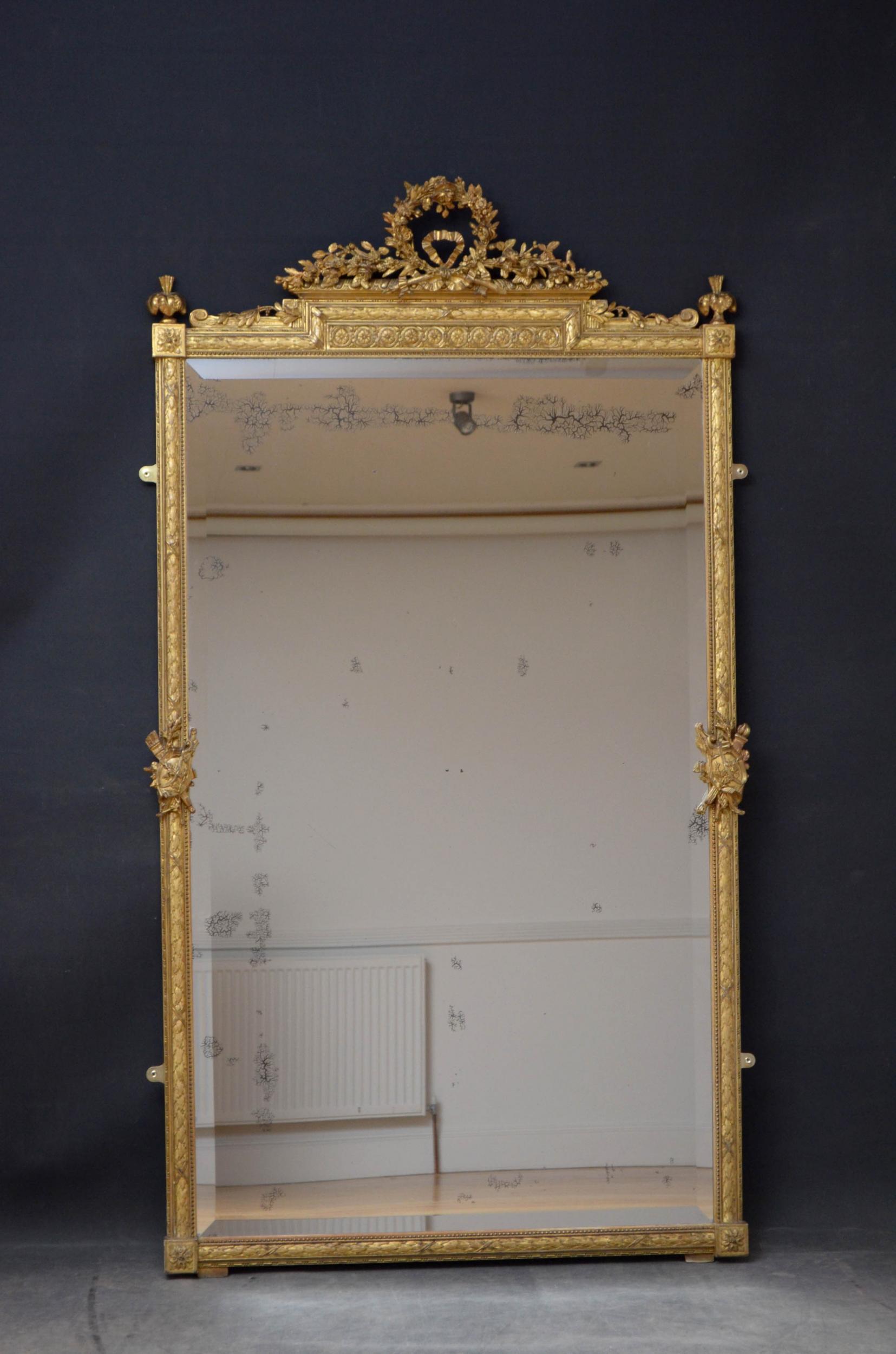 Sn4999 a fine quality 20th century French antique gilded overmantle or floor standing mirror, having a finely carved and elaborate floral garland cresting, an intricate carved border with appliqués depicting the arts and original beveled edge plate