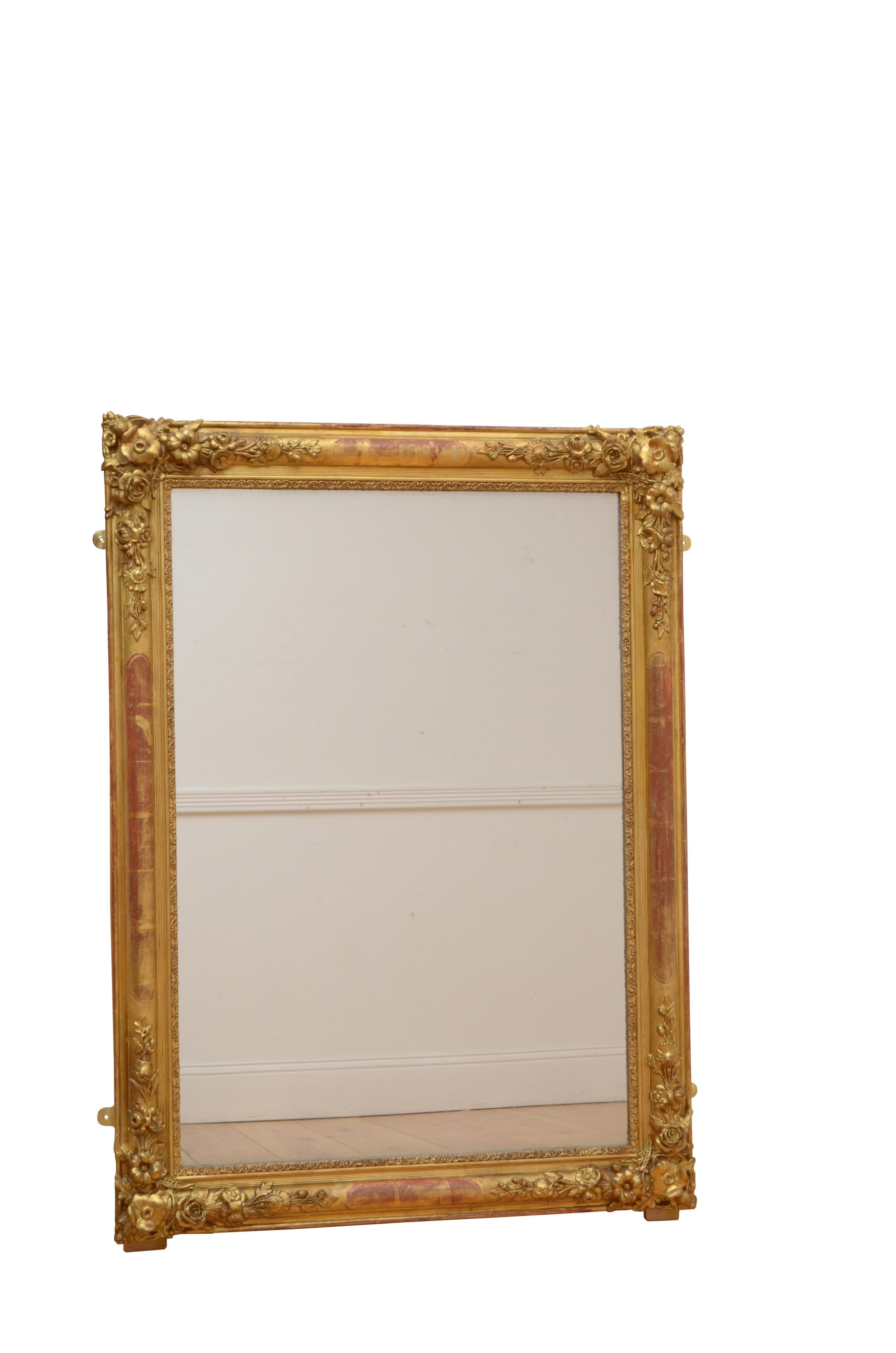 0233 outstanding French gilded wall mirror of versatile form, can be positioned horizontally or vertically, having original glass with characterful air bubbles, sparkle and minor silvering in moulded giltwood frame with flower carved corners. This