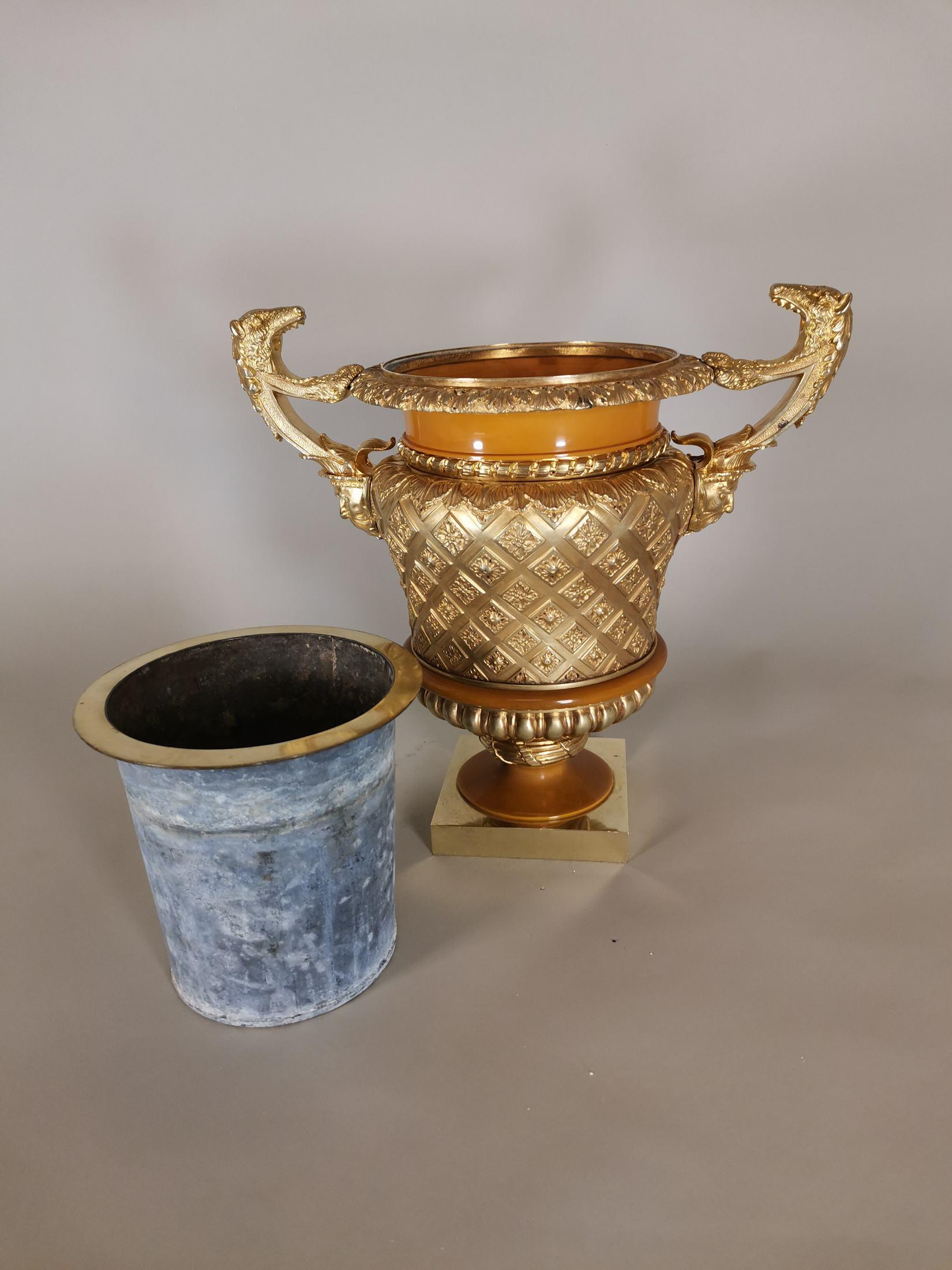 jh. Vase aus vergoldeter Bronze und dekoriertem Zelluloid mit Henkeln in Form eines grotesken Gesichts und eines Tierkopfes.
Maße: 30 x 26 x 18 cm.