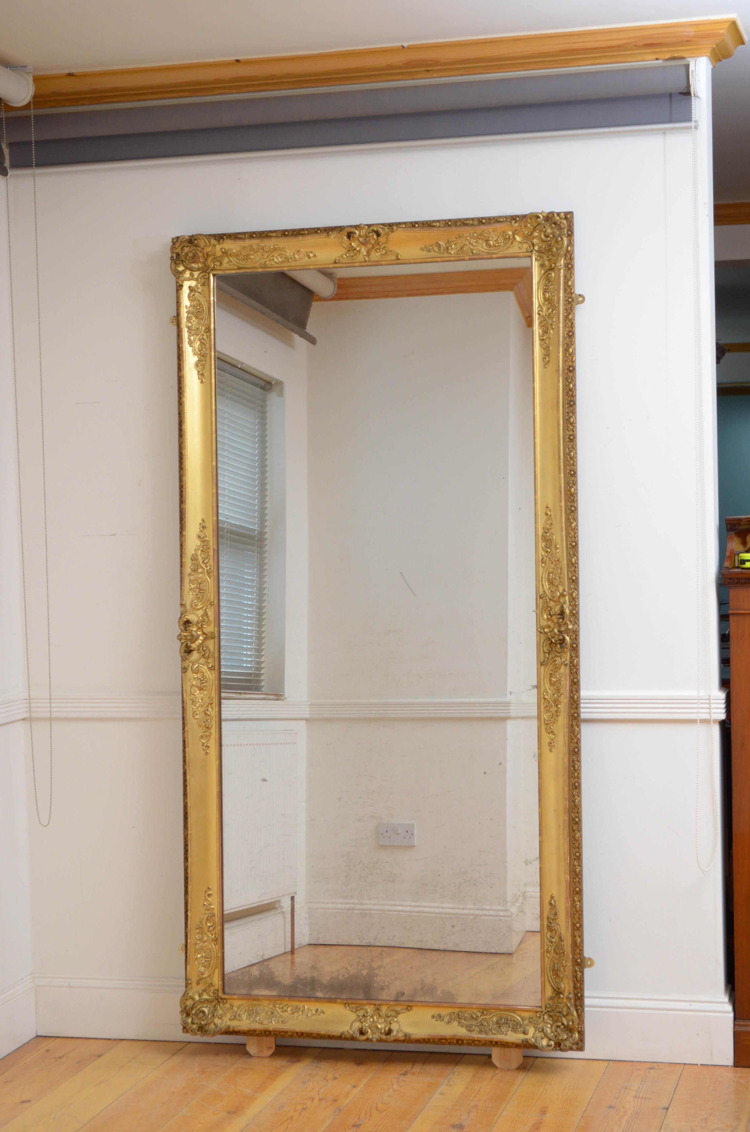 K0 Superb XIXth century French giltwood mirror of versatile form, can be position horizontally or vertically, having original glass with characterful foxing in giltwood frame. The frame is decorated with scrolls and floral motifs to each corners and