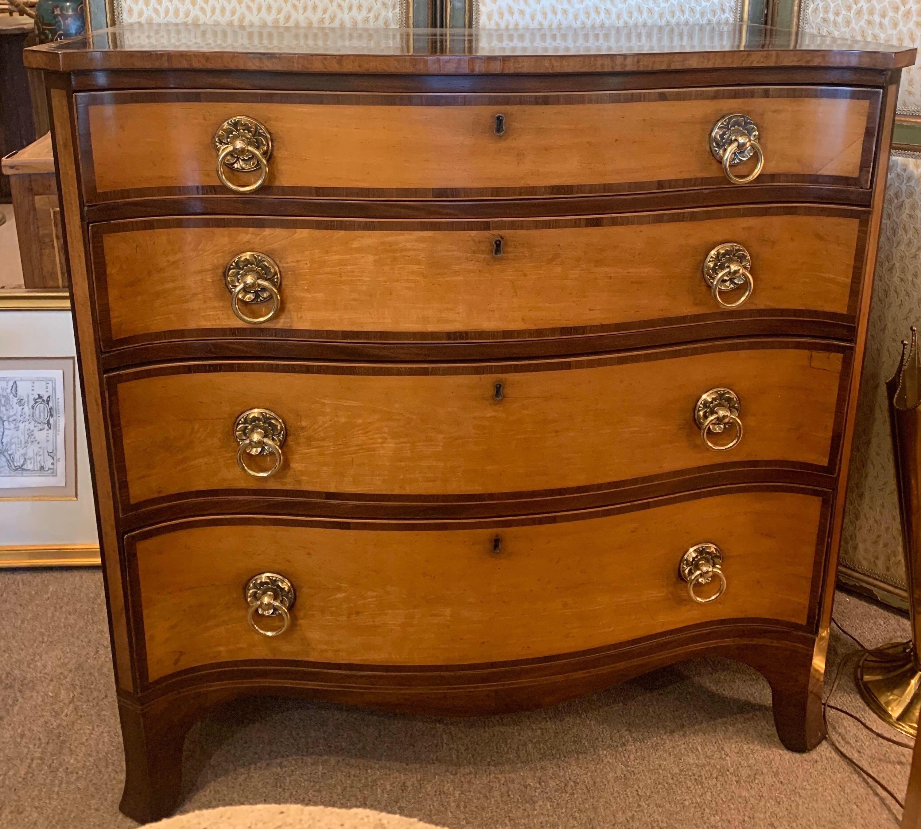 Incredibly handsome 18th century mahogany and maple serpentine chest later retailed by renown London cabinetmakers and antiques dealers, Edwards and Roberts. Gorgeous crotch mahogany and English maple used on this chest with 4 graduated drawers and