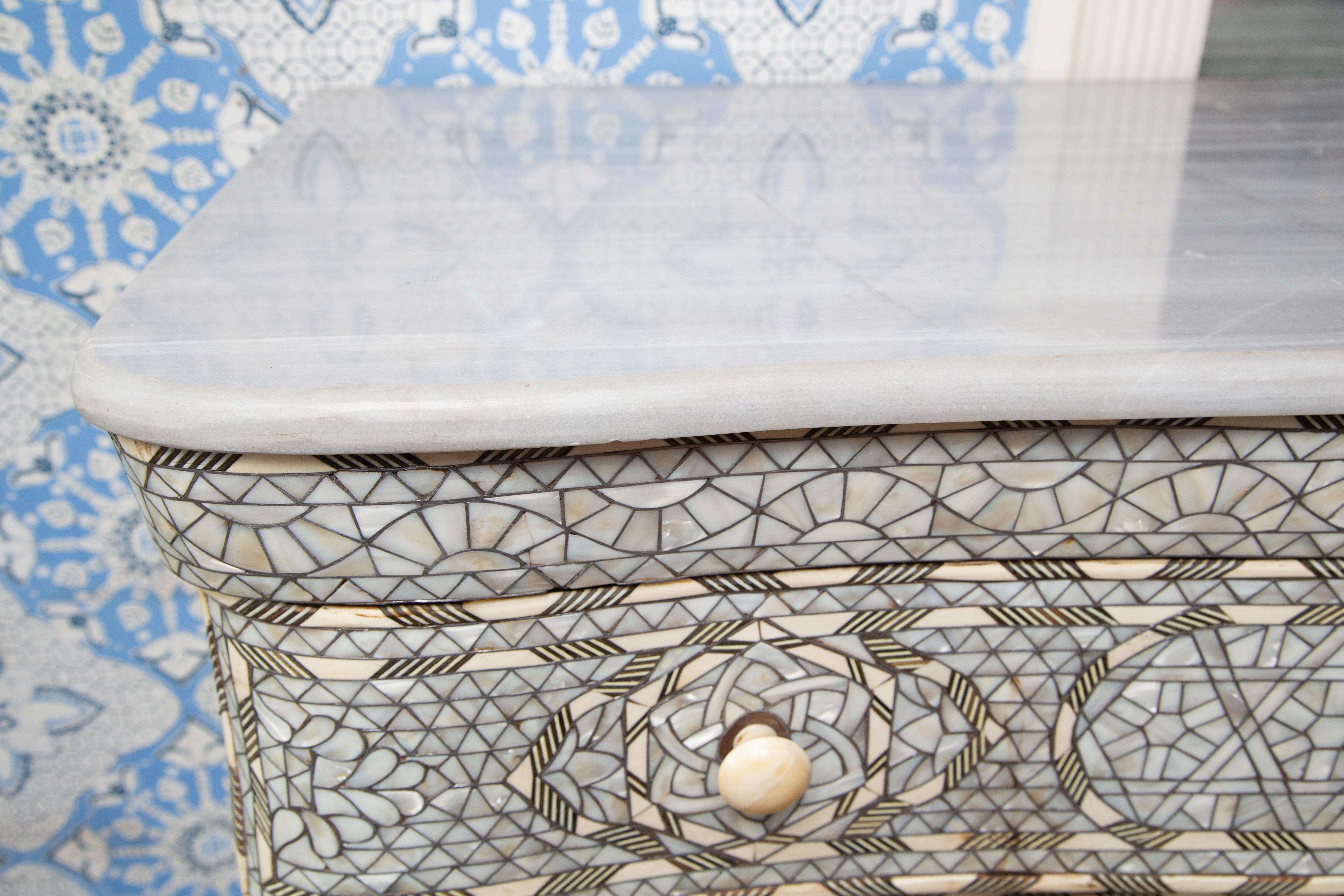 Stunning antique five-drawer wooden dresser chest of drawers with mother of pearl inlay from Syria. This piece has a white mother of pearl front, brown sides with patterned mother of pearl inlay. The top is brown and has a separate white marble top.