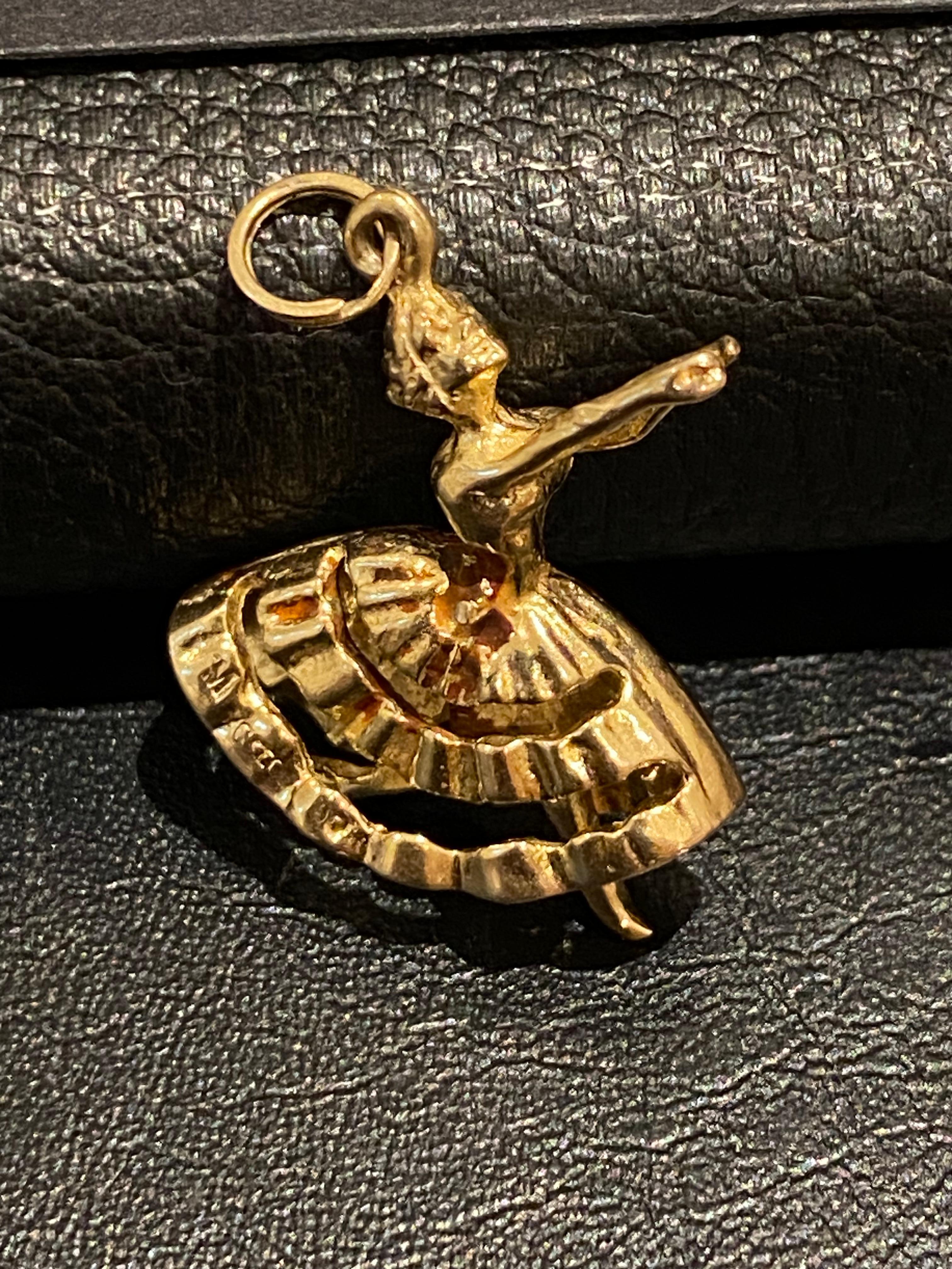 Intricately designed as a dancer 

(or ballerina), wearing a long, finely detailed skirt & 

with her legs moving, 

this exquisite charm is performed 

in 9K yellow gold & 

 

Bearing English hallmarks: 

9ct 375 gold stamp & letter date c1961 


